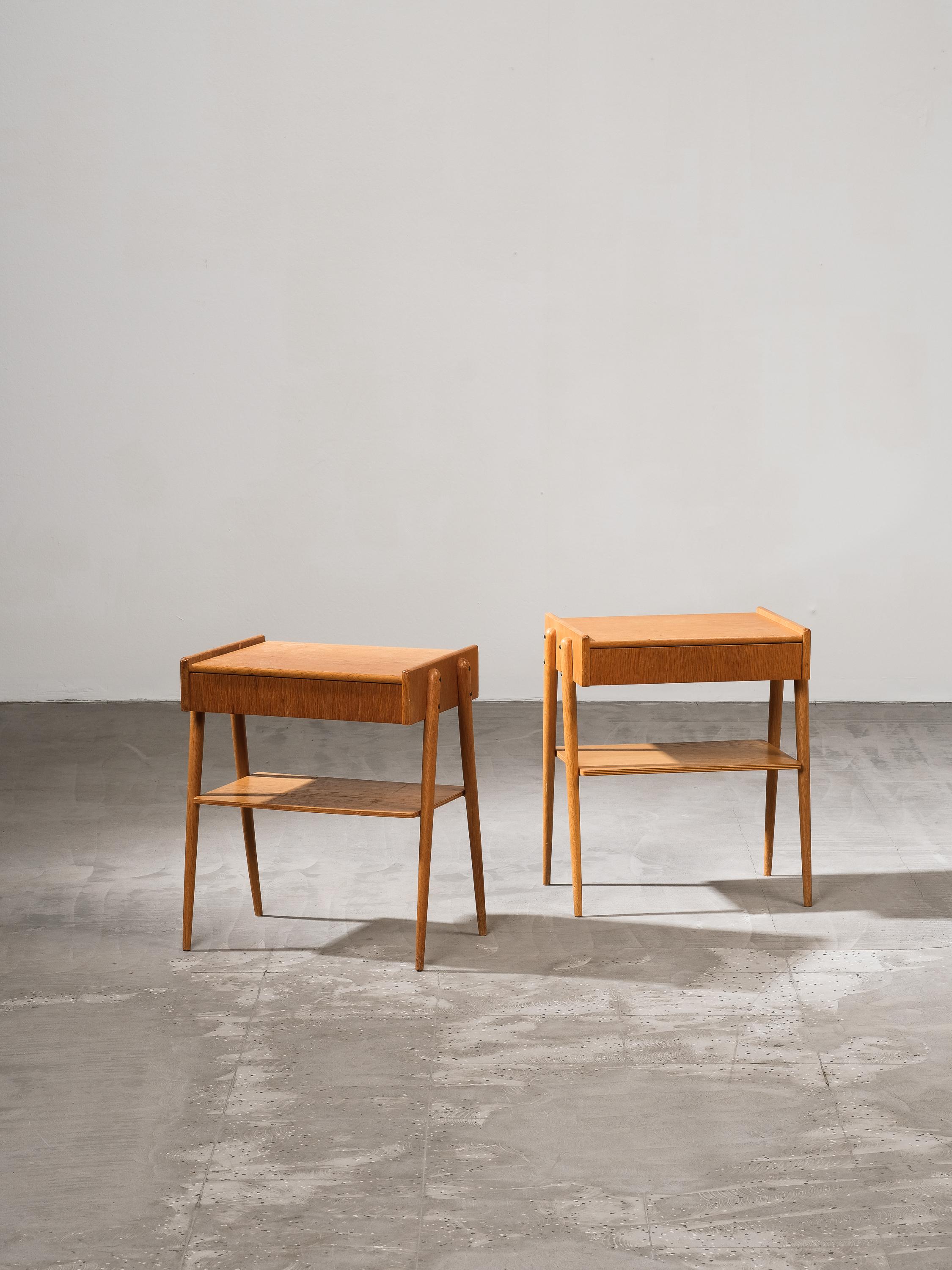 Magnifique ensemble de deux tables de nuit / chevets en chêne avec tiroir des années 1950, fabriqué par Carlström & Co Möbelfabrik en Suède.
L'état général des deux tables de nuit est bon. Légère décoloration et quelques marques sur le plateau de la
