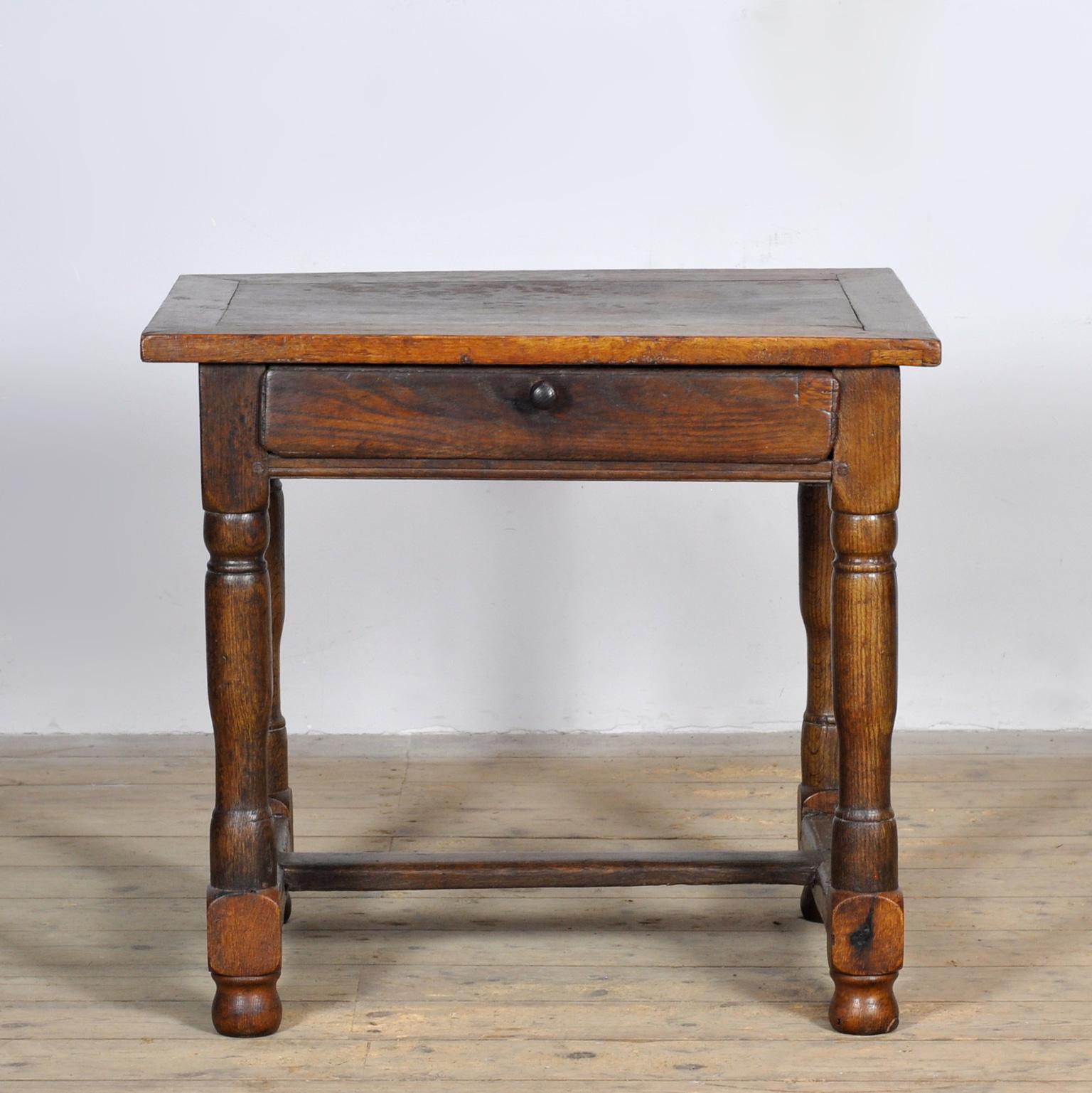 Auténtica mesa de pago de roble del siglo XVII/XVIII, con signos distintivos de desgaste que atestiguan su larga historia. Debajo de la encimera hay un cajón con el pomo de madera original. La mesa descansa sobre cuatro patas bellamente torneadas,