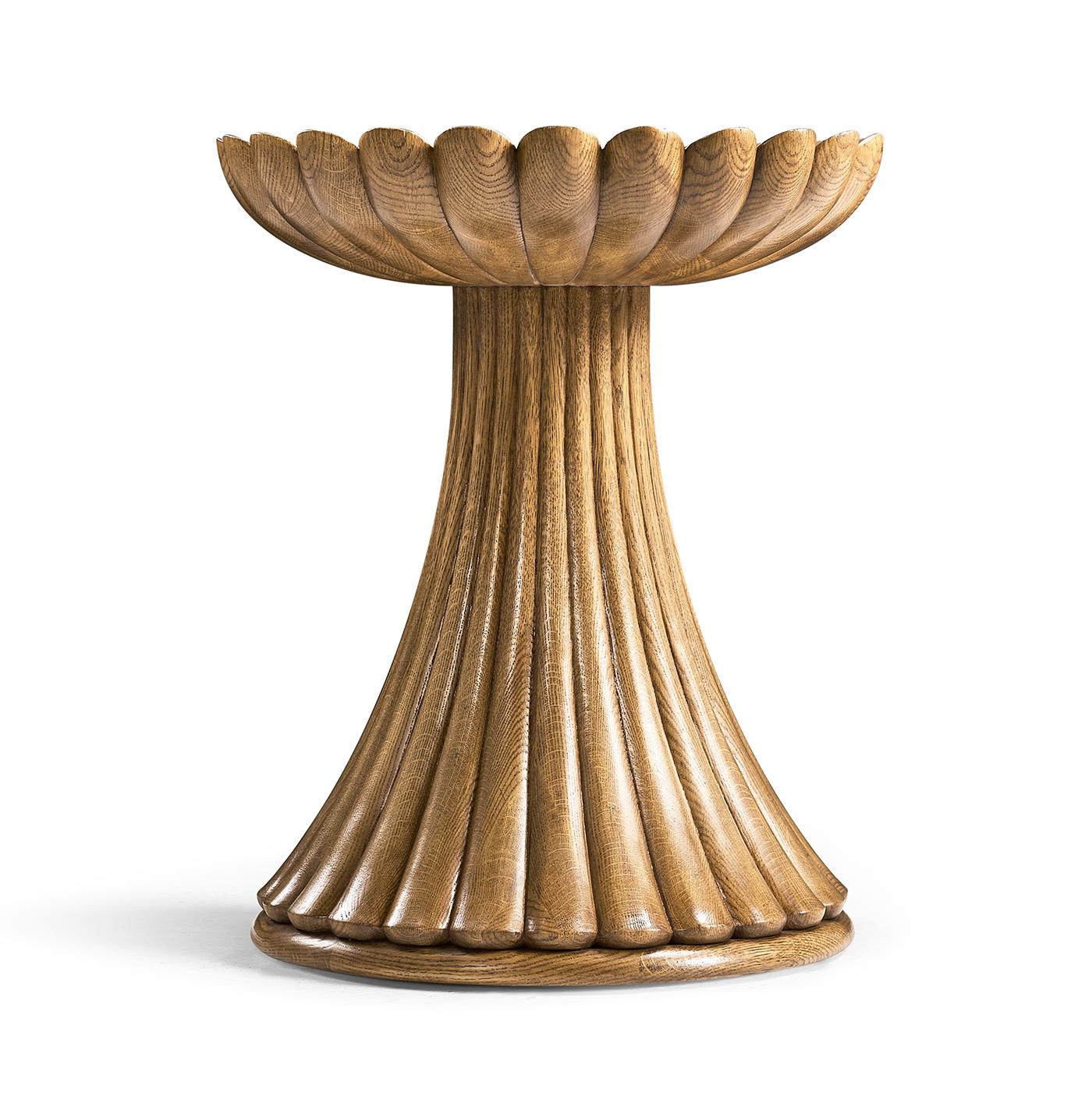 Fabriquée en chêne massif avec une finition chaleureuse, cette table dégage une chaleur naturelle, ce qui en fait un ajout polyvalent à n'importe quel espace. La base sculptée à la main, qui présente une disposition circulaire frappante de lobes