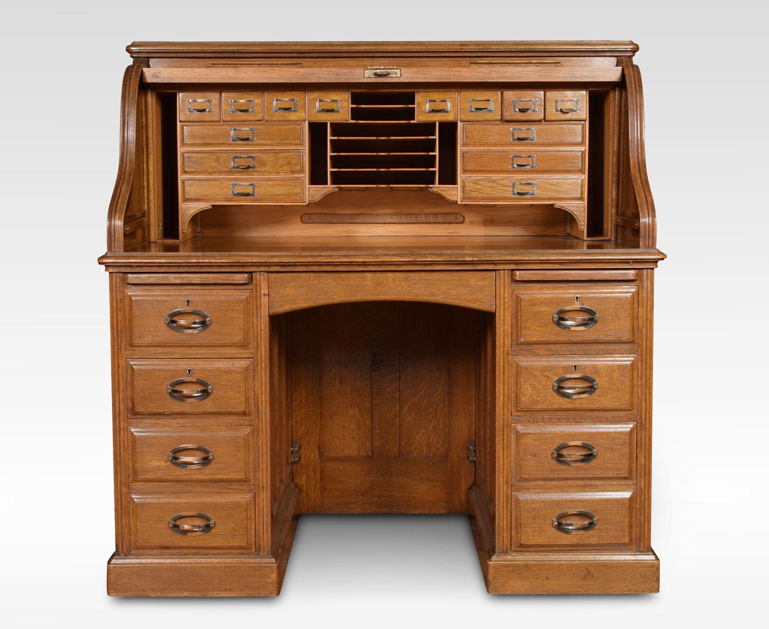 Oak double pedestal roll top desk, the high back with fitted interior of pigeon holes and drawers, the centre drawer flanked by pedestals one with four short draws the other with two short and one double draw raise up on plinth