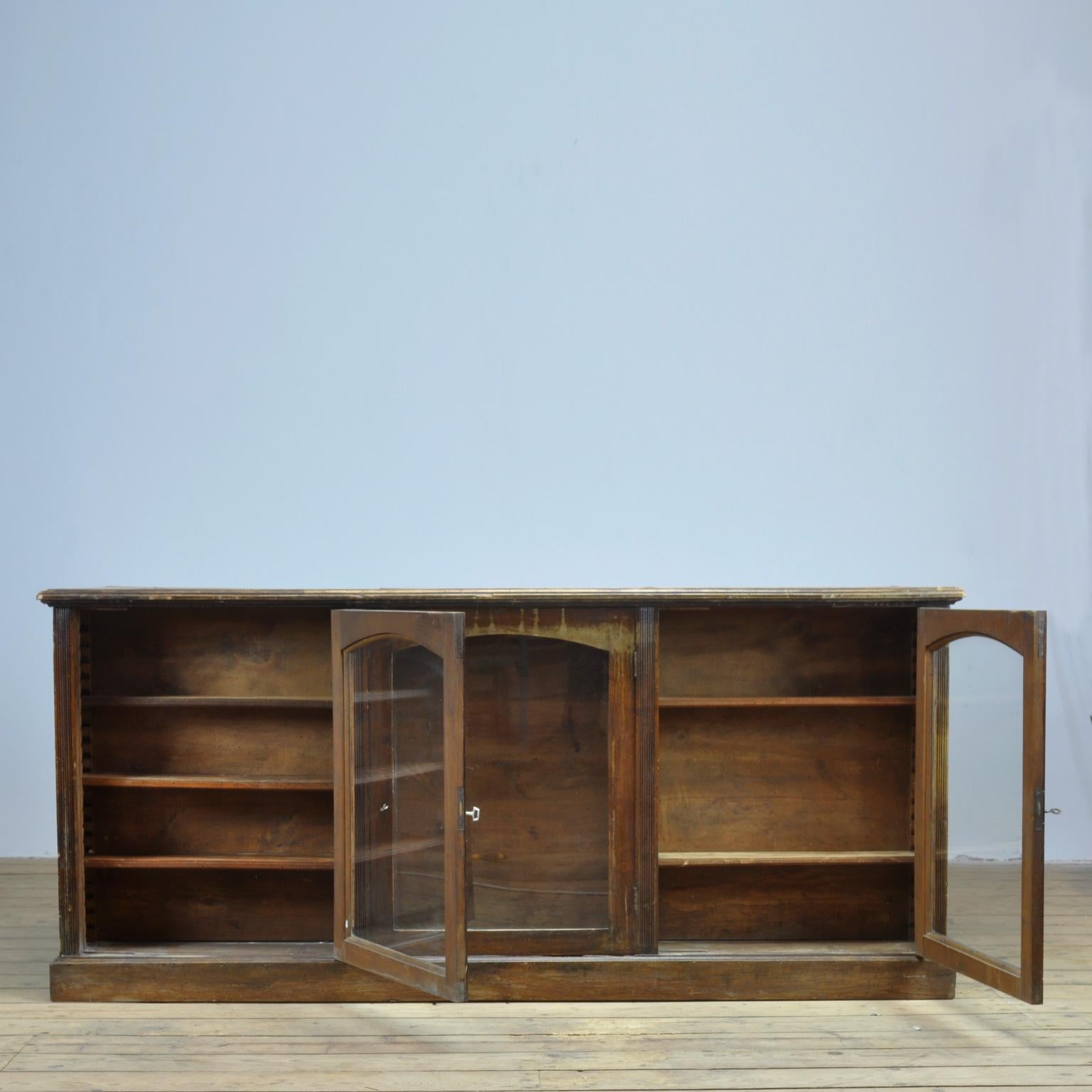 Oak pharmacist counter from the 1930s. On the front 3 glaxed doors with shelves. On the back 13 drawers (on two of them the original signing) and 6 shelves.