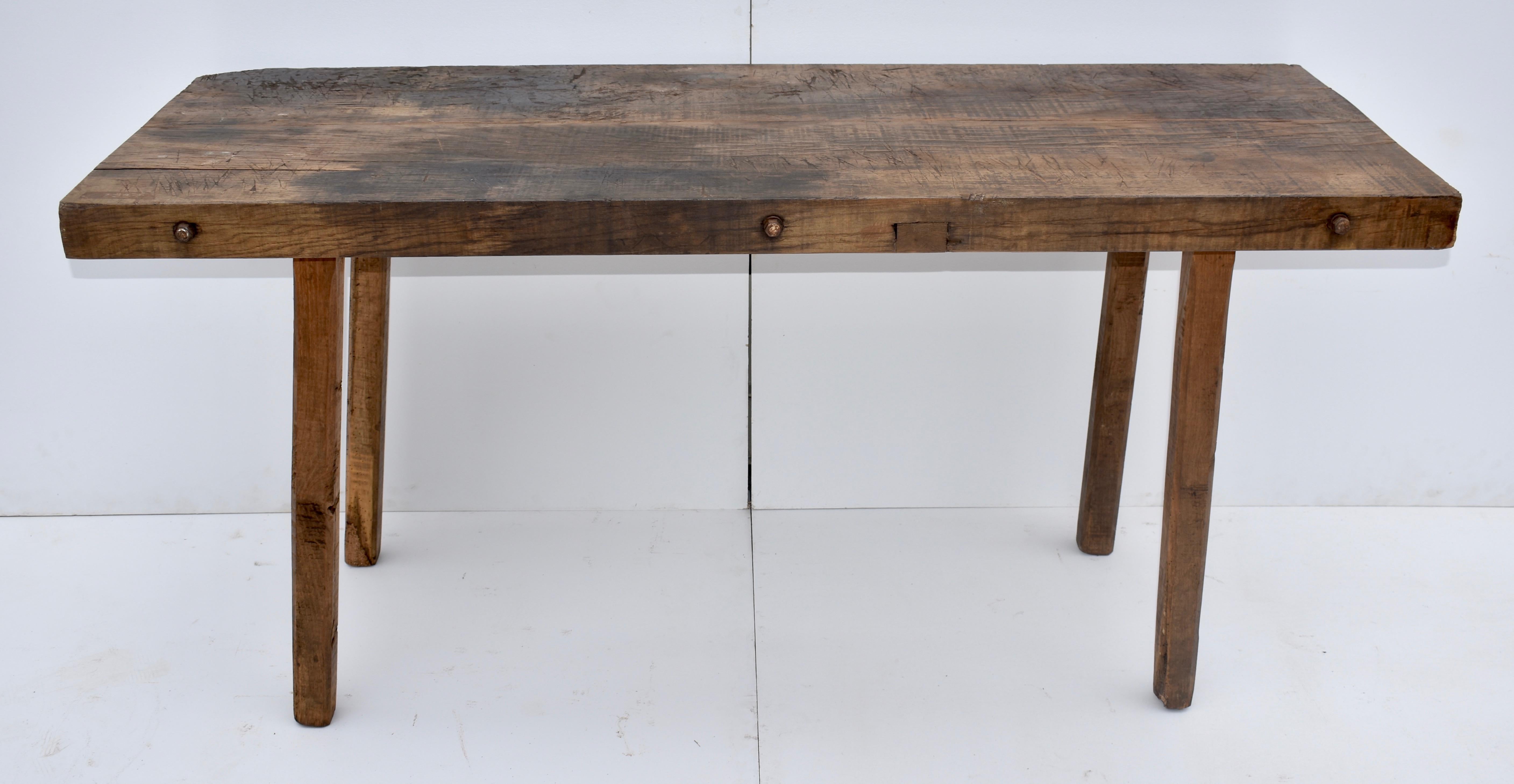 The top of this outstanding pig bench is made from two massive slabs of oak, three inches thick, pulled tightly together with three iron bolts which pass through the center of the boards. It bears the scars of decades of relatively light use and