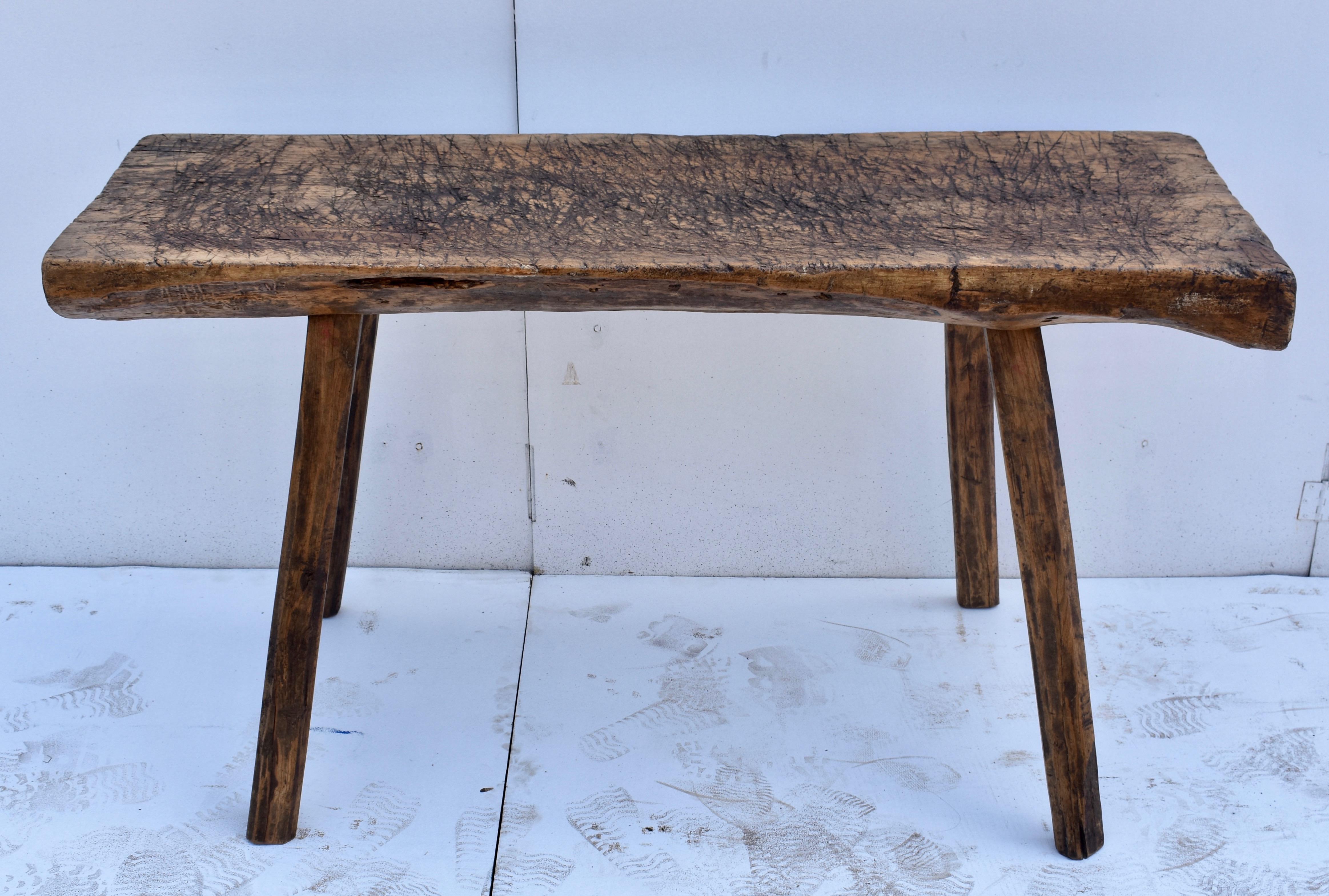 The top of this oak pig bench is a single slab of oak almost 4” thick and it still retains the rounded underside of the log from which it was hewn. It is criss-crossed, chopped and gnarled and even cupped a little through decades of purposeful use.