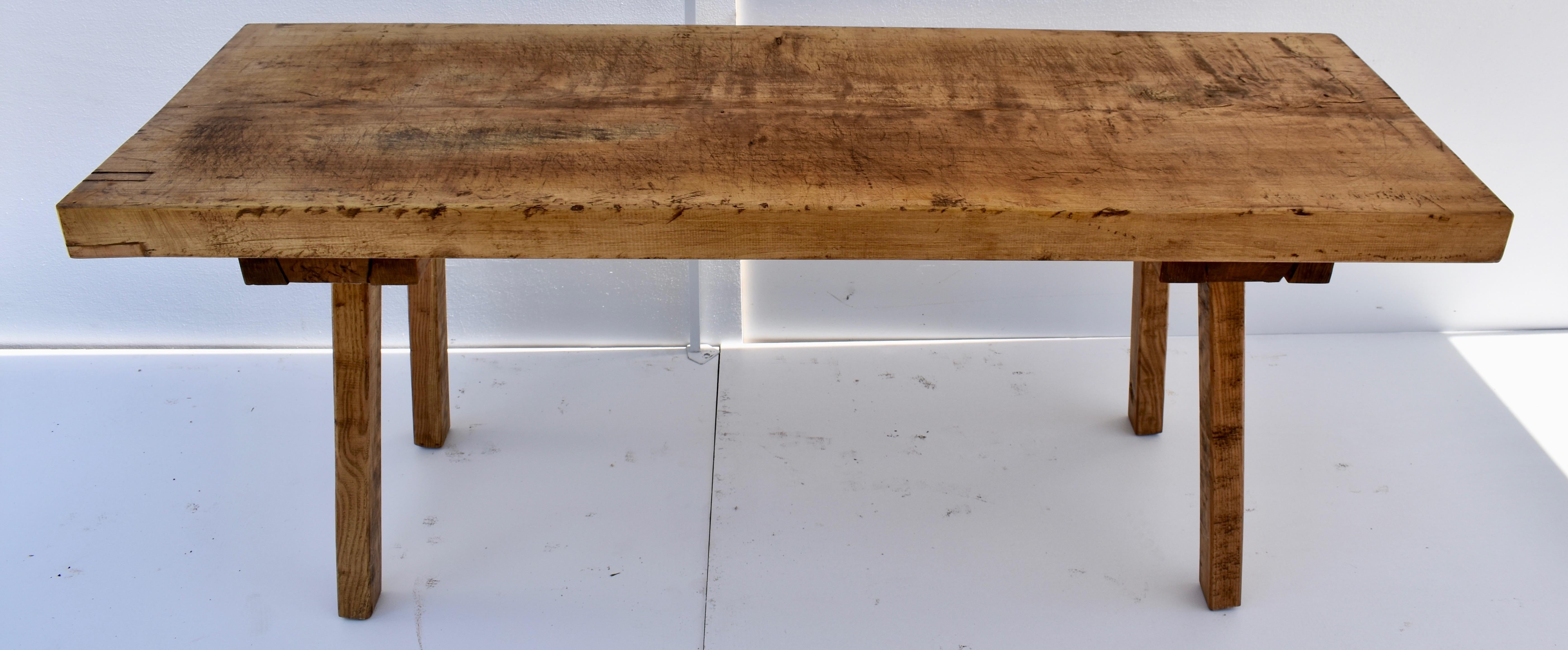 This massive oak pig bench butcher’s block has a single 3” thick slab for a top. The hand-hewn splayed legs are mortised into sturdy cross members which are screwed to the underside of the slab. These make great side tables, sofa, or work tables, or