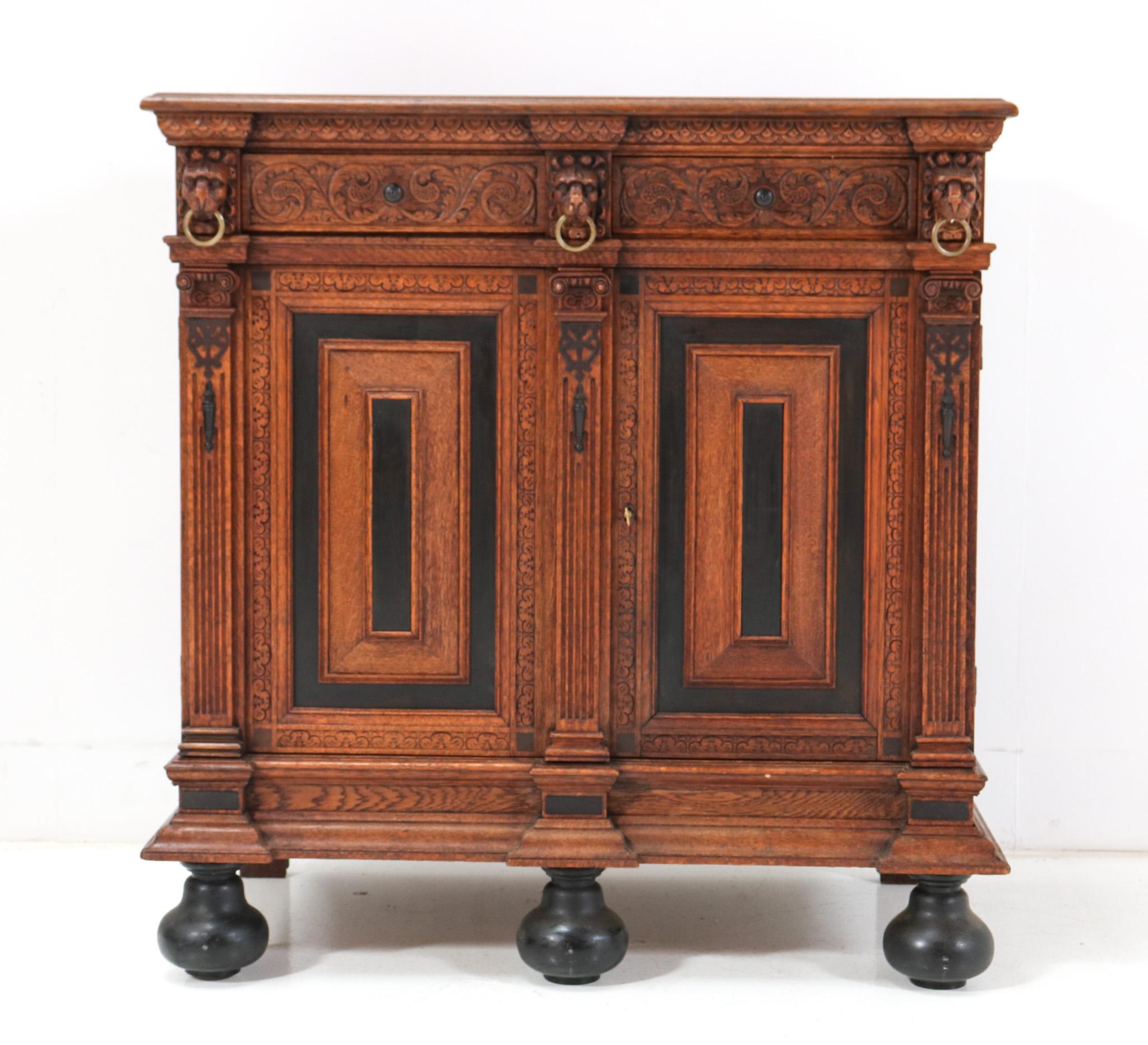 Stunning and rare Renaissance Revival cabinet.
Striking Dutch design from the 18th Century and manufactured in the 1900s.
Solid oak base with three original hand-carved lion heads and hand-carved decorations on the two drawers.
The backside is