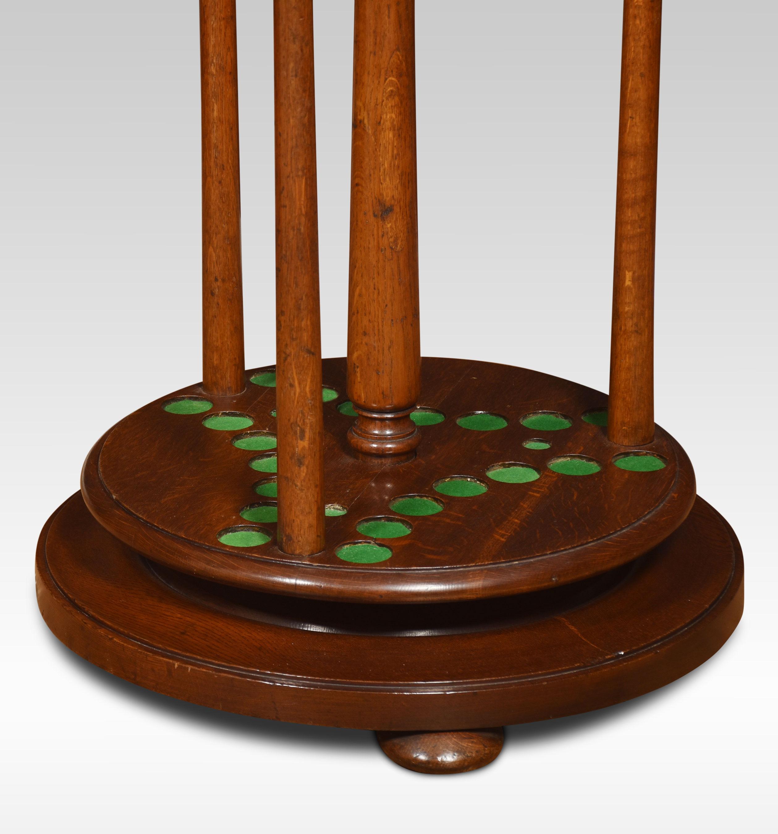 Oak cue stand, having central turned finial above cue rack accommodating 21 cues, all raised up on turned pillars and stepped base terminating in bun feet.
Dimensions
Height 44.5 Inches
Width 24 Inches
Depth 24 Inches.