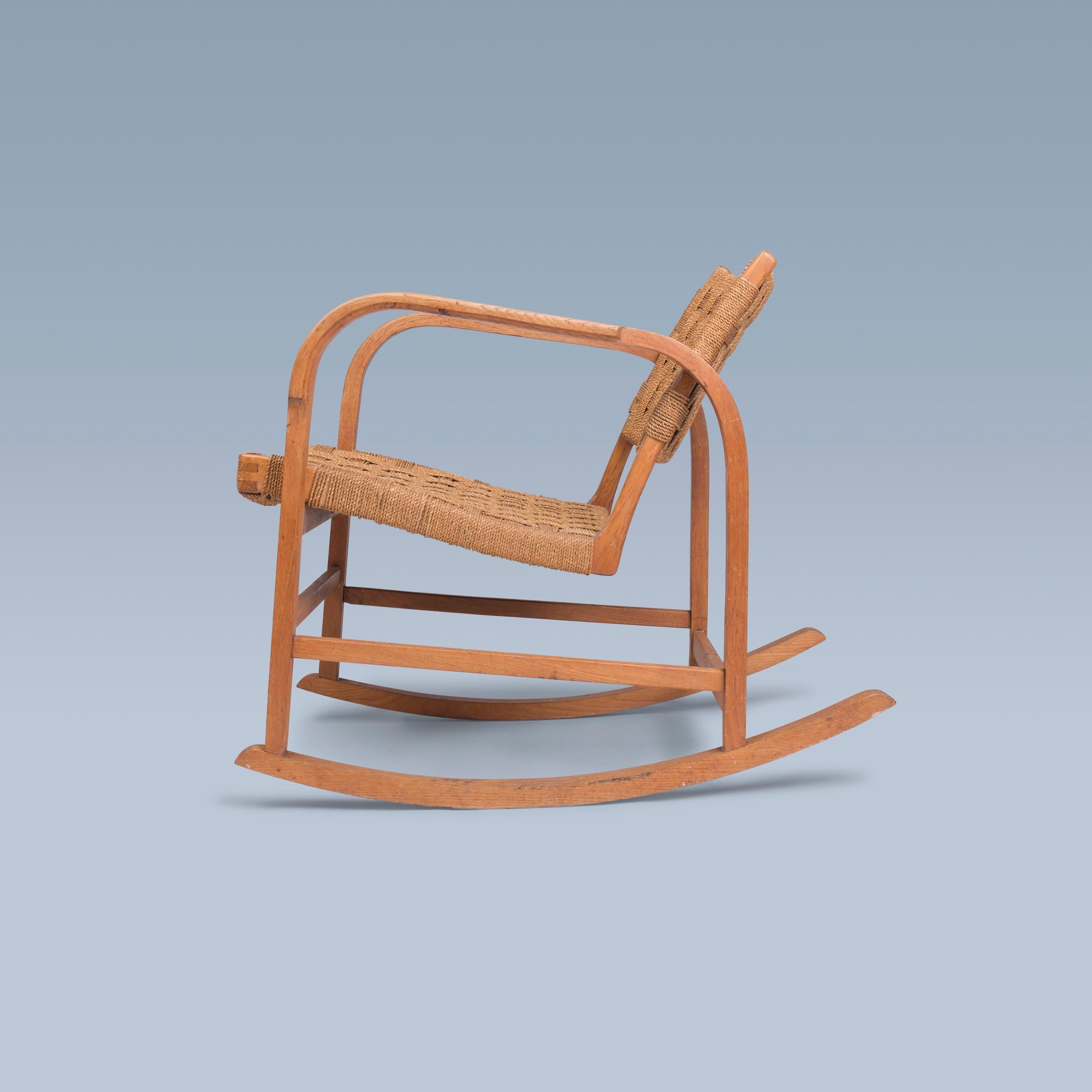 This rocking chair of patinated oak frame designed by Magnus Læssøe Stephensen (1903-1984) has seat and backrest of original woven seagrass.

It was executed by cabinetmaker Clausen in Brørup, Denmark. ca. in the 1930s.

Similar model presented at