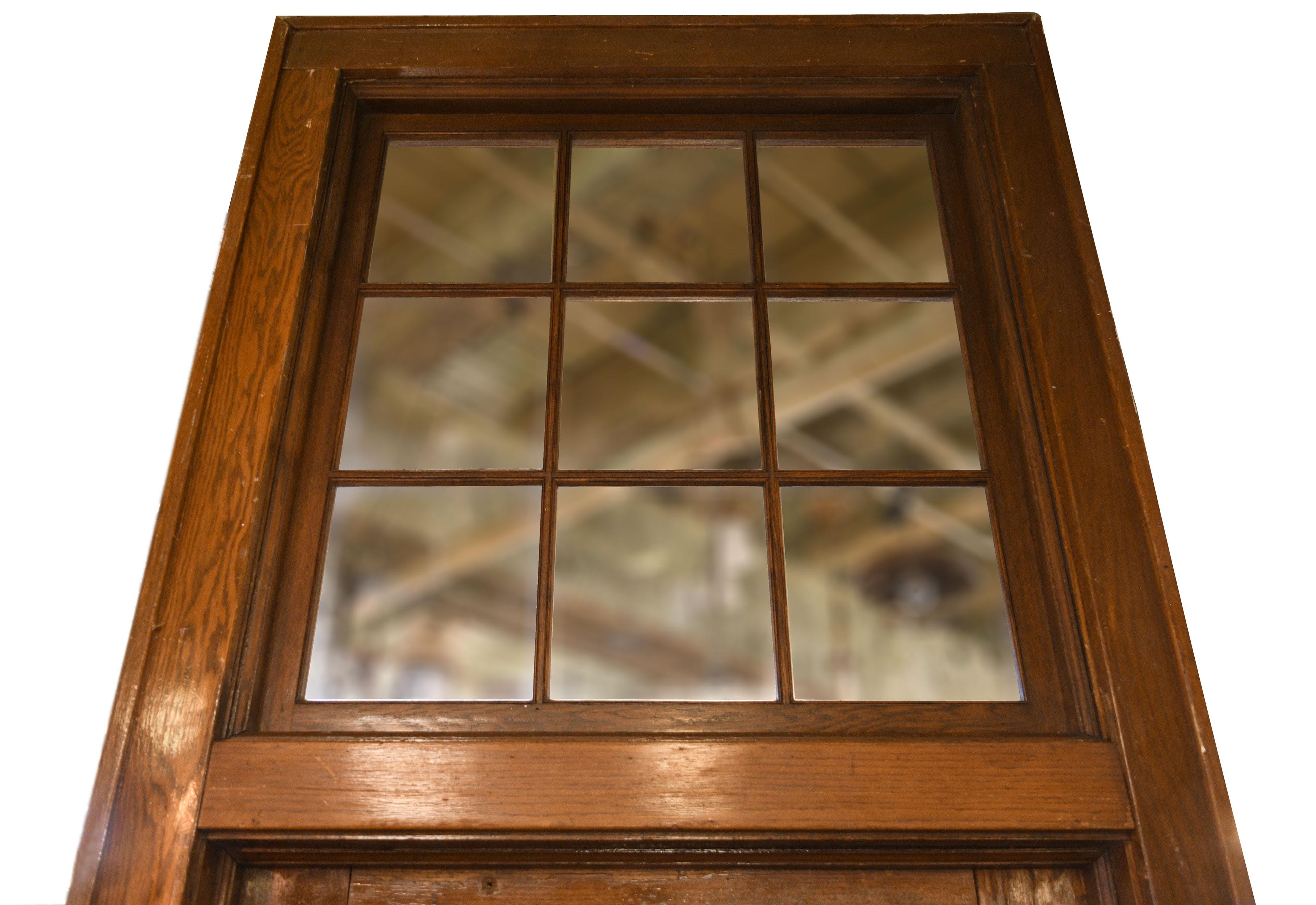 This beautiful oak schoolhouse door is not your average door! This piece towers over the average person standing at 10 feet tall! Included with the door is a frame that features a transom separating the actual door from the nine panel window sitting