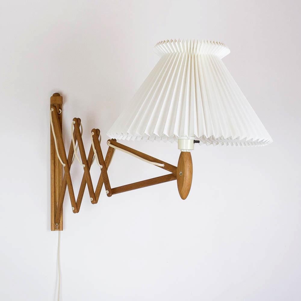 Extending wall-mounted oak scissor light by Erik Hansen for Le Klint with Le Klint shade.
Measures: Height 40cm, extendable width 56cm to 100cm.
