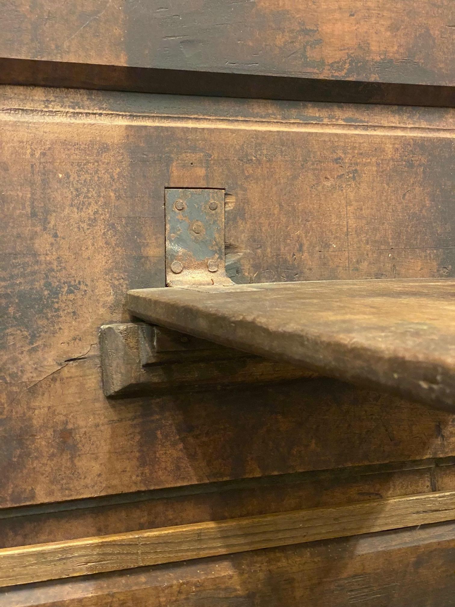 Solid oak settle with integrated drop down table.  Hand carved detailing throughout with forged iron hinges and hardware.  Solid and sturdy construction with subtle joinery techniques gives this functional period piece lots of character and appeal. 