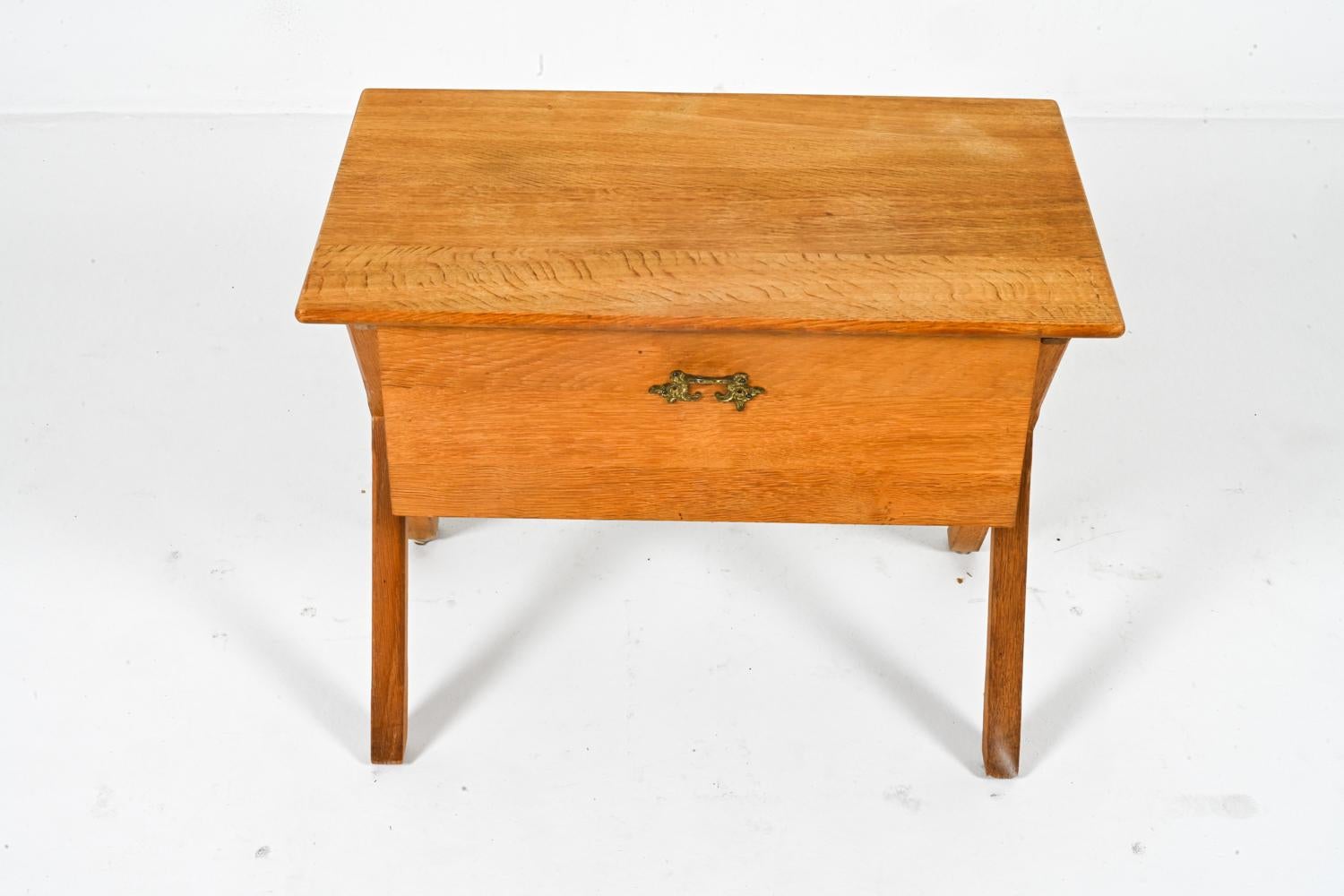 This Danish sewing table exemplifies the perfect marriage of form and function that characterized Mid-Century Modern design in the 1960's. Crafted from warm, honeyed oak, this table boasts bold lines and a timeless elegance that will effortlessly