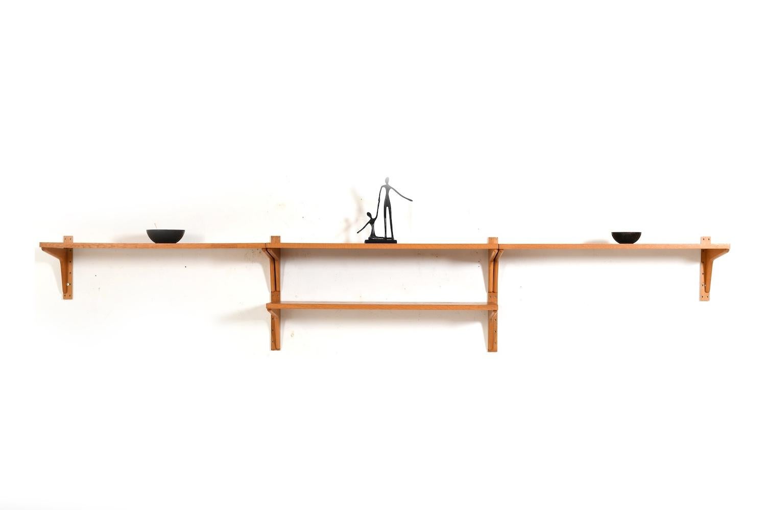 Sistema de estanterías de roble de HG Furniture Dinamarca, década de 1960.
La unidad mural consta de:
- 4 estantes
- 4 soportes de pared

medidas detalladas:

estanterías: 4x  89,5 cm x 30 cm (ancho x fondo), altura de los soportes de pared: 2x 47,5