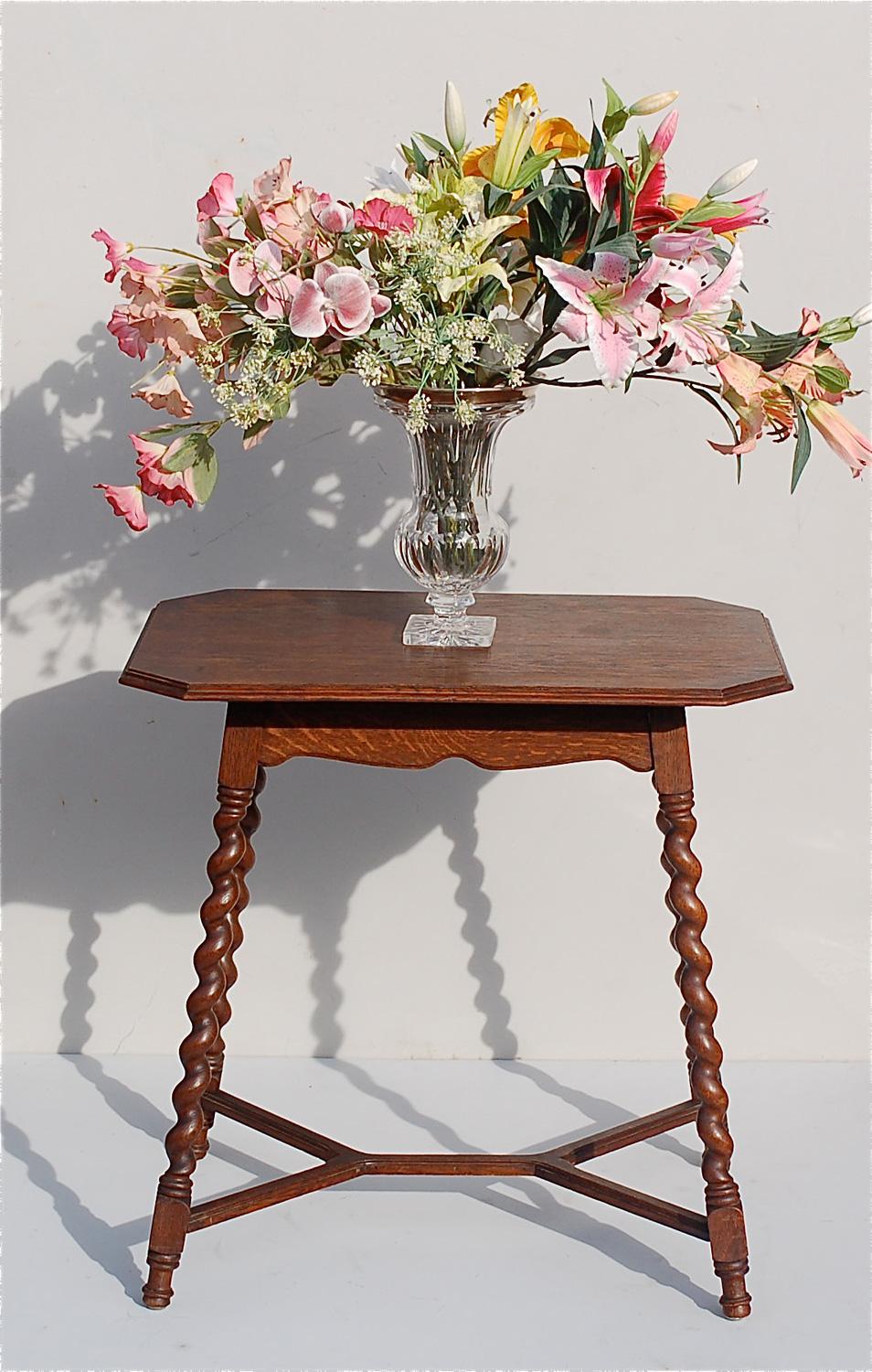 Rustic, country style side table or occasional table on an A-line base. The top is a rectangular shape with angled corners, like a stretched out octagonal shape. The barley twist legs are joined by stretchers for added strength. The legs terminate