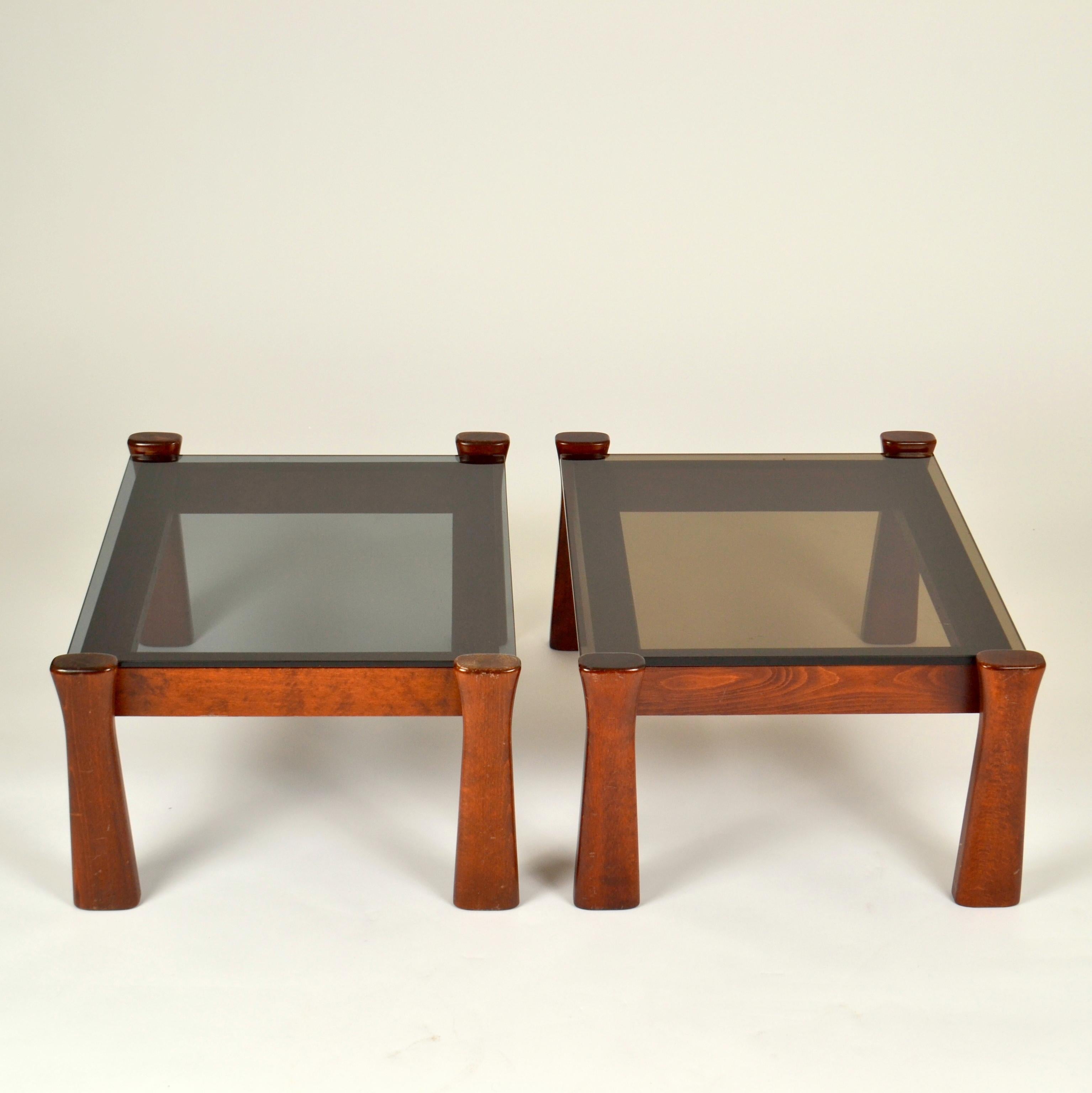 Paire de tables d'appoint italiennes en chêne massif teinté avec plateaux en verre fumé. Leurs pieds sont effilés, ce qui leur confère une forme esthétique. Il s'agit d'un modèle italien fabriqué dans les années 1970.

Les sommets ont des tons