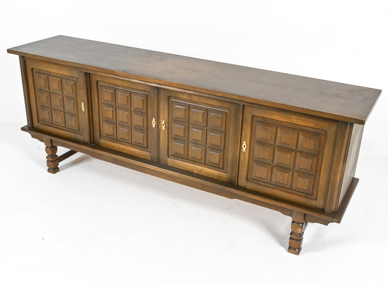 This exceptional sideboard embodies the essence of Danish Modern design, expertly crafted from solid oak by renowned furniture designer Henning Kjærnulf. His signature style is evident in the bold and classic carved design, most notable on the front