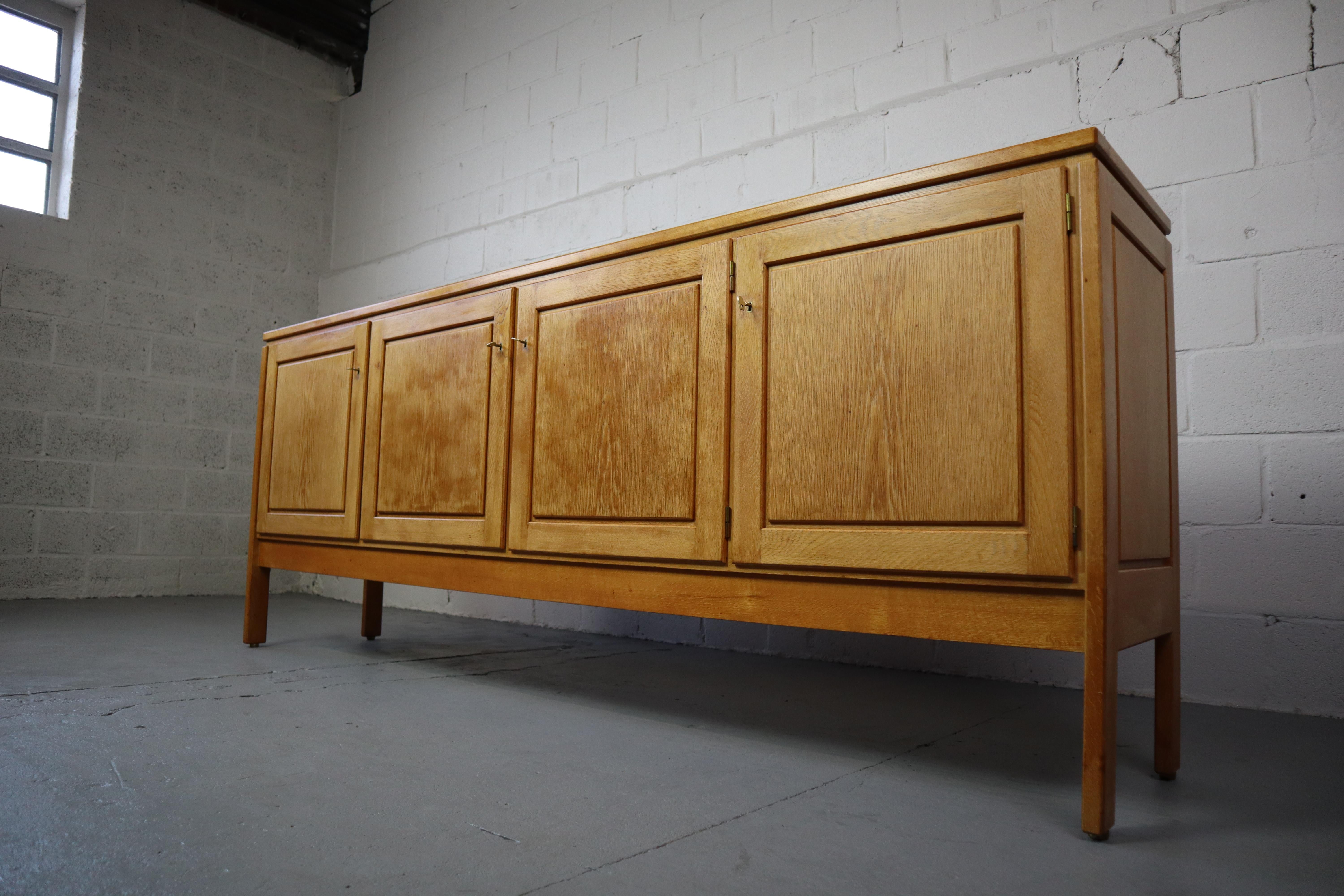 Oak sideboard by Jos De Mey for Van den Berghe-Pauvers, 1970s.
This sideboard features four large doors and five drawers.
Each door opens and closes with a brass key. The cabinet is labelled on the inside as shown in photos. All together a