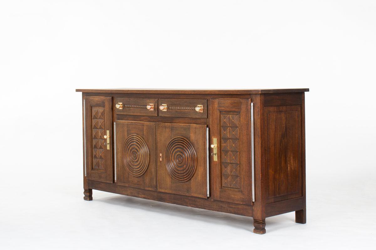 Conçu dans les années 1950 par le designer français Étienne Kohlmann, cet élégant buffet illustre le fonctionnalisme raffiné du mobilier moderniste d'après-guerre.

Fabriquée en chêne massif, cette pièce présente des lignes architecturales épurées,