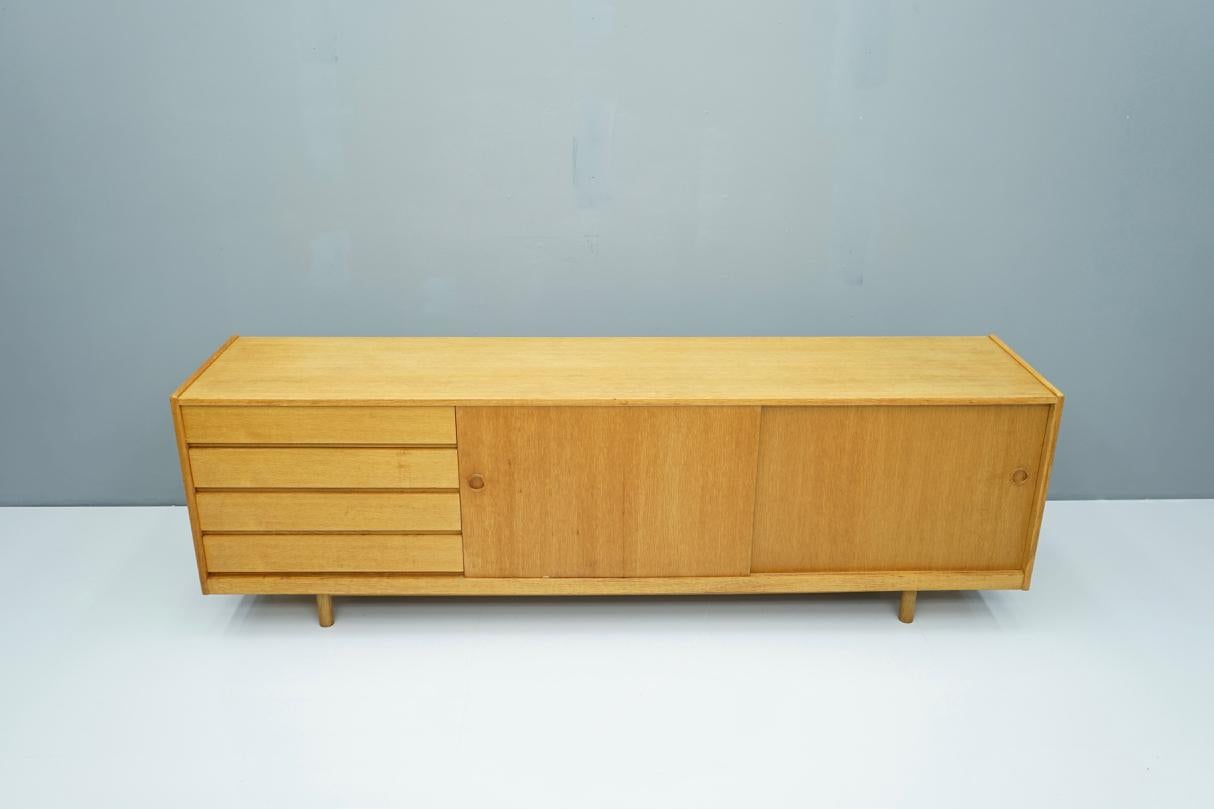 Low oak sideboard with two sliding doors and four drawers, Denmark, 1960s.
Good original condition.