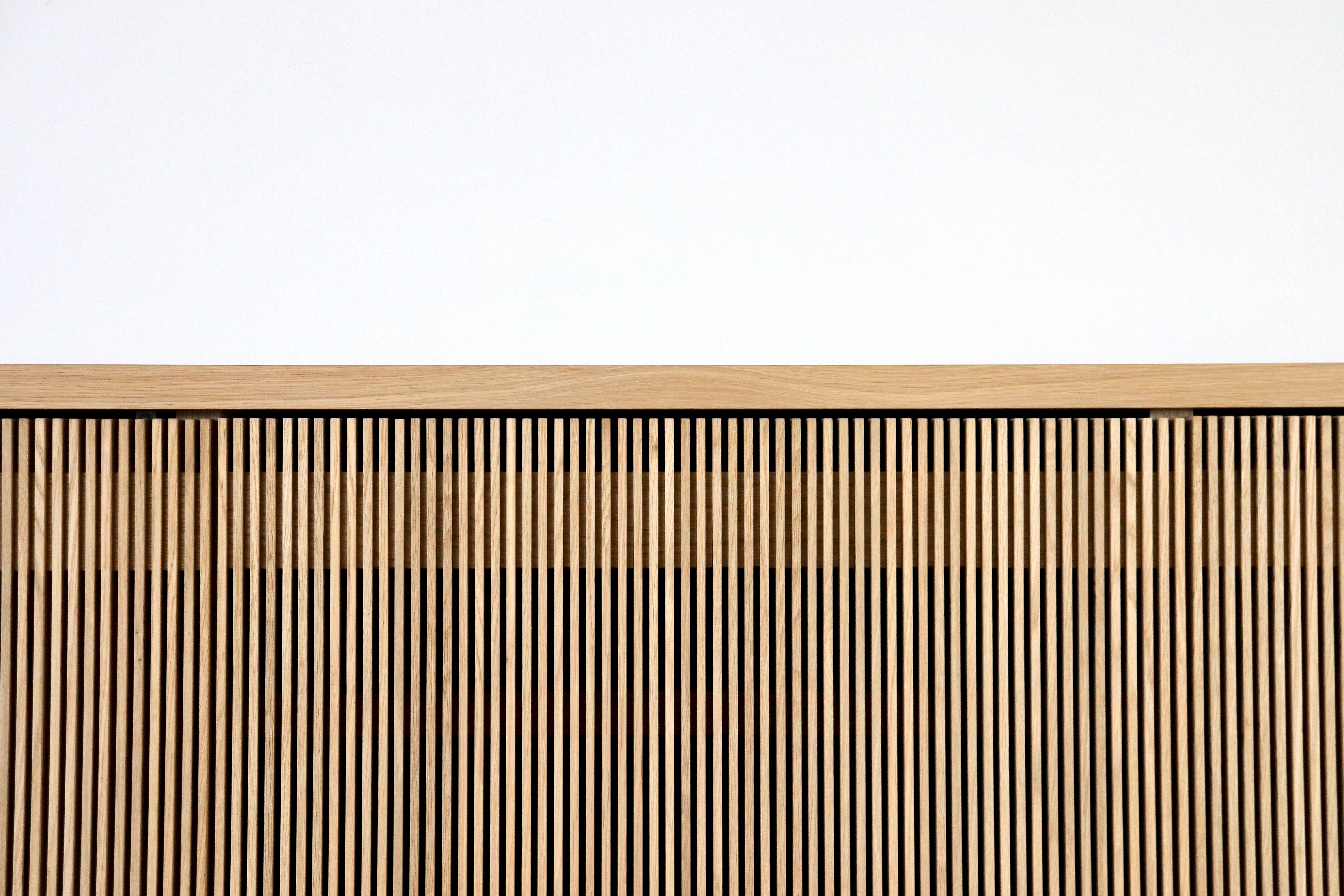 Solid wood credence / sideboard with slatted screen doors in white oak. Designed and built by Fieldwork in Portland, Oregon with mortise and tenon joinery, the clean modern lines and quiet texture of this piece are perfect for building layered