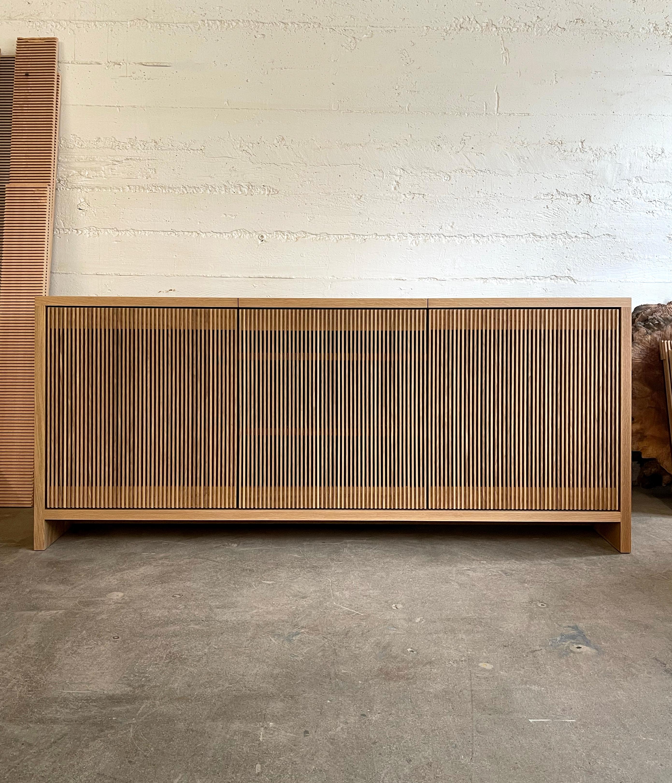 Solid wood credenza / sideboard with slatted screen doors in white oak built by Material in Portland, Oregon. This piece is outfitted with a top hatch door for access to a space for a record player. Shelves are optimized for album storage. The clean
