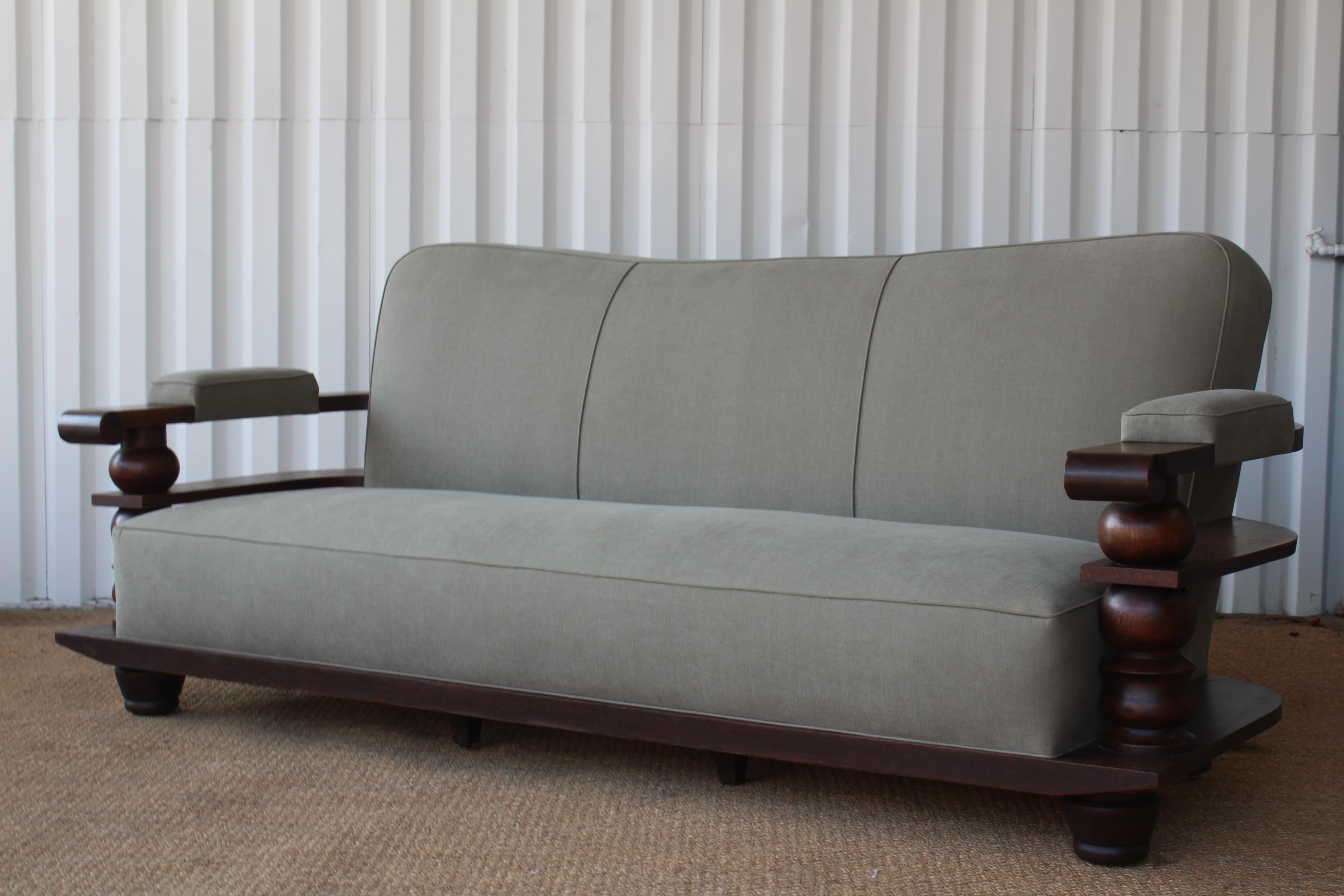 Oak framed 1930s sofa from a hotel in Biarritz, France. In the style of Charles Dudouyt. Newly reupholstered in a soft olive green linen.