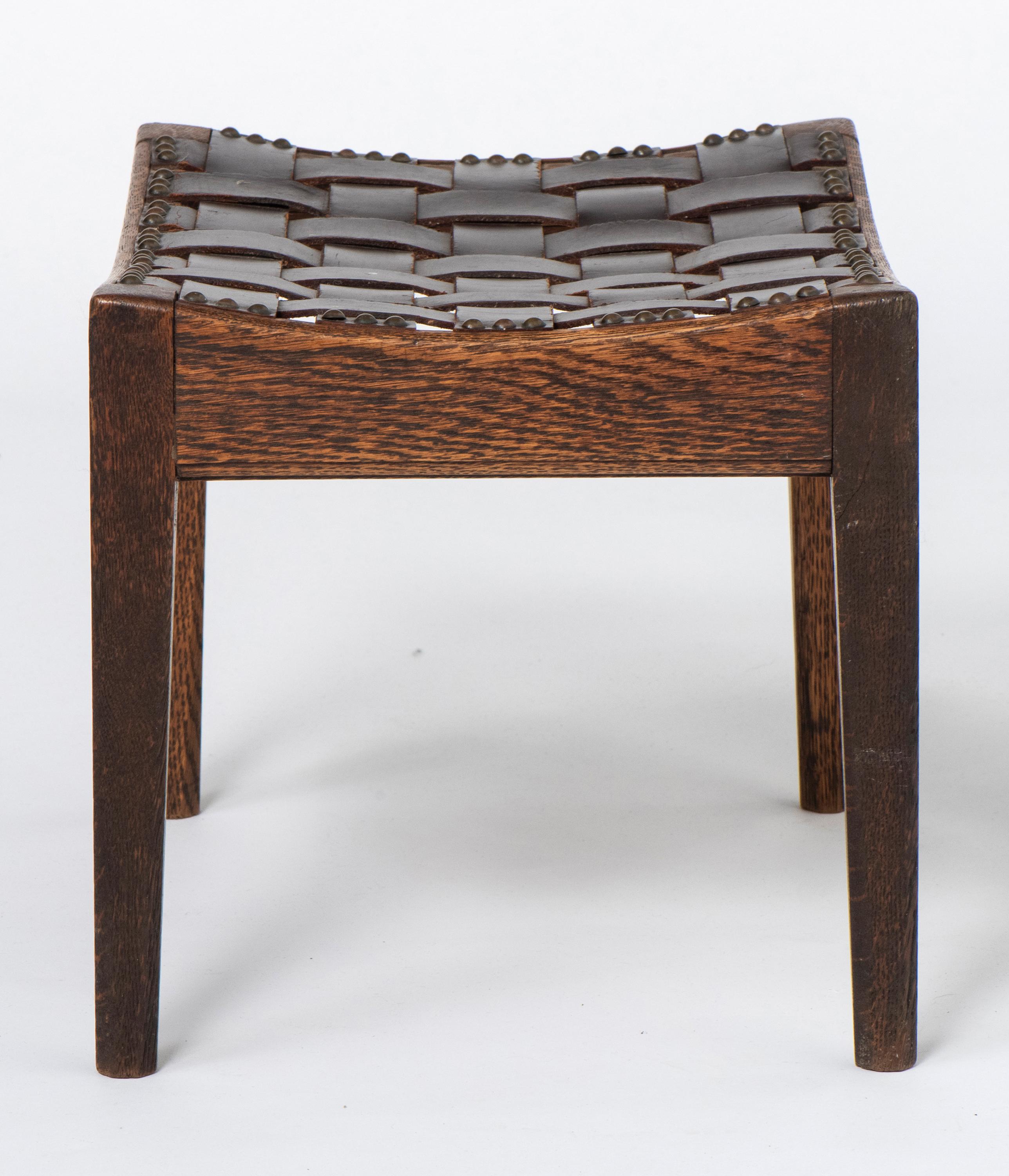Oak stool by Arthur W Simpson of Kendal. (1854-1922)
Of simple rectangular concave seats with leather slatted tops.
Tapering legs.
England, circa 1920
Measures: 40 cm wide x 30.5 cm deep x 30.5 cm high.
 