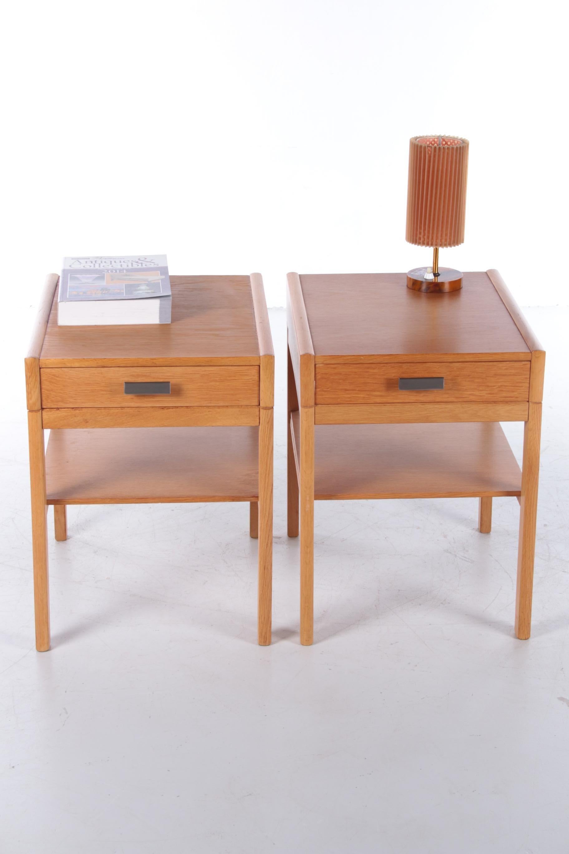 This set of two mid-century bedside tables is from Sweden and was produced in the 1960s.

The bedside tables are made of sturdy and light oak wood. Each bedside table has a drawer and an extra shelf so that you can easily store all your