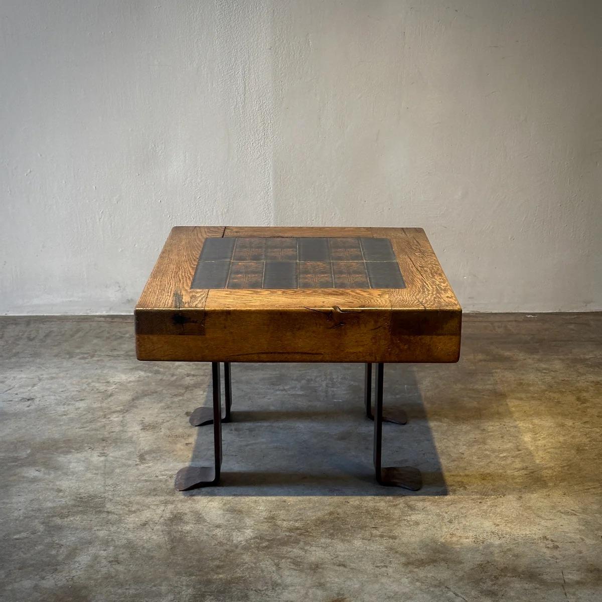 Questo tavolo in rovere francese presenta una straordinaria combinazione di legno naturale e piastrelle di ceramica intarsiate, sostenute da robuste gambe in ferro. La meticolosa lavorazione delle piastrelle aggiunge un tocco artistico distintivo
