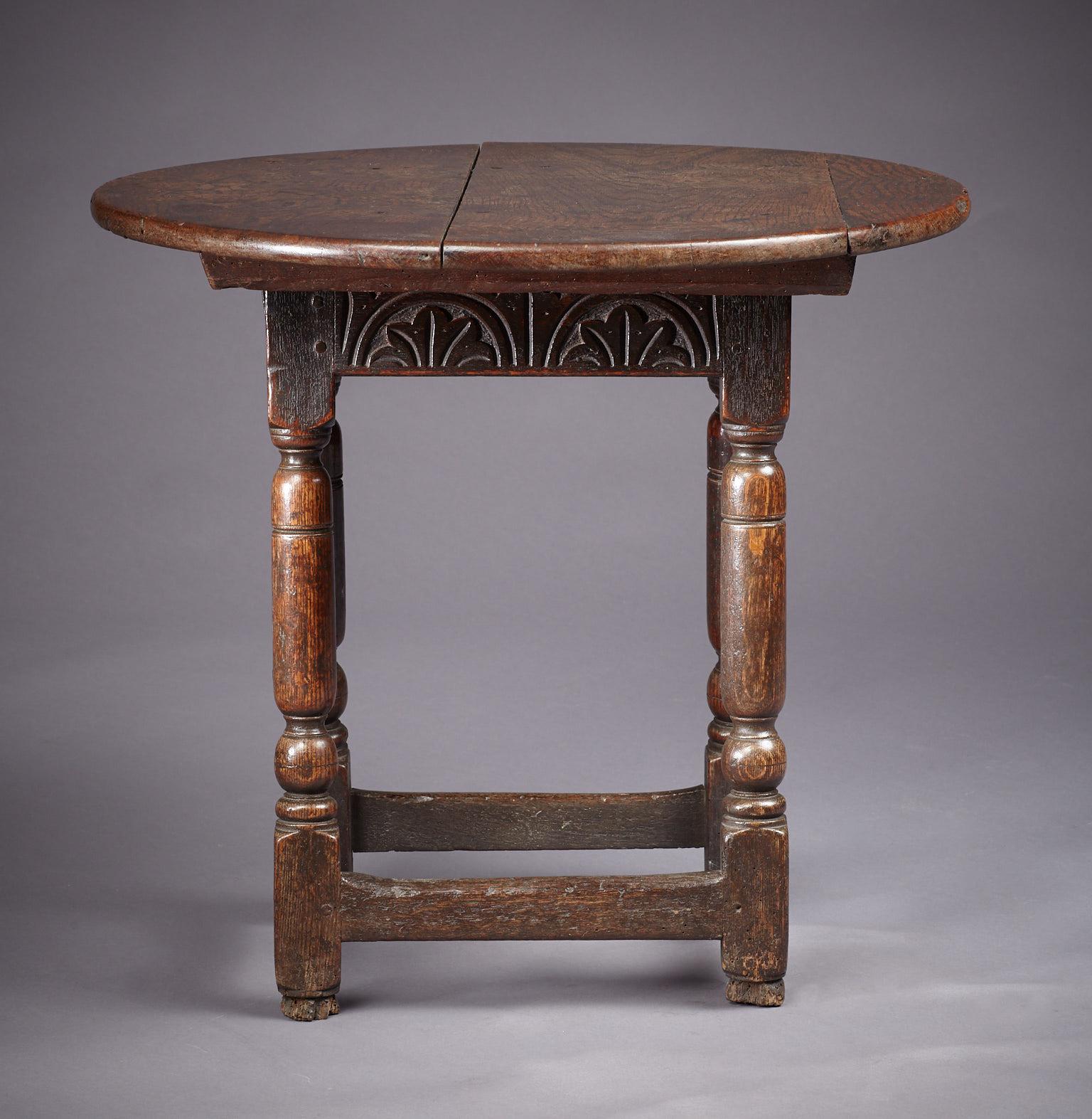 Charles I to Commonwealth period oak joined table stool, with the rare feature of original sliding circular secondary top. The stool base with rectangular top, above lunette carved frieze rails joined by bold baluster and ball turned legs, with