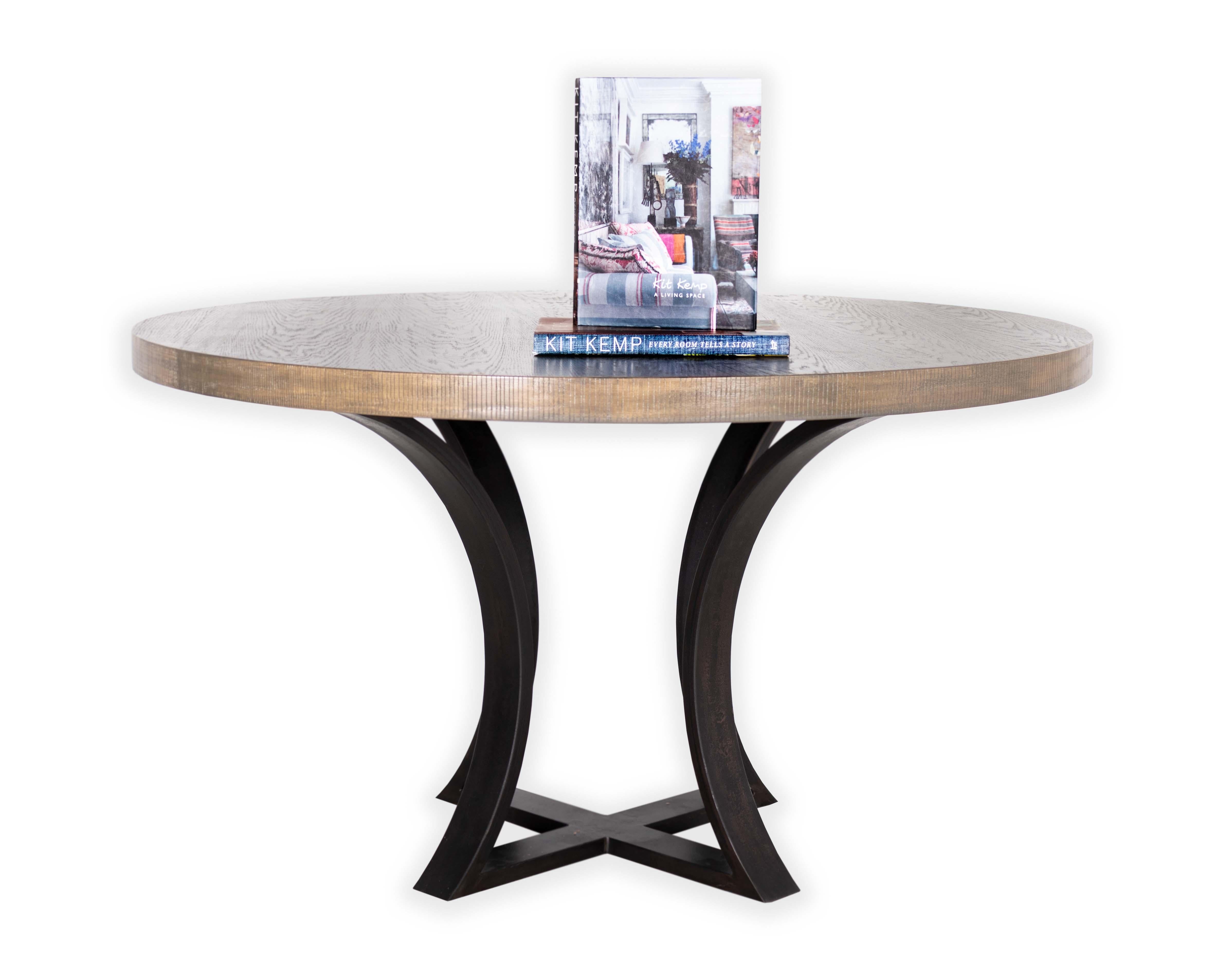 Round oak dining table wit dime edge in a Bombay finish with a ebonized curved leg base. 
This item is crafted from natural materials. Coloring and detailing may vary, adding to its uniqueness.

Dimensions, stone type and metal finish can be