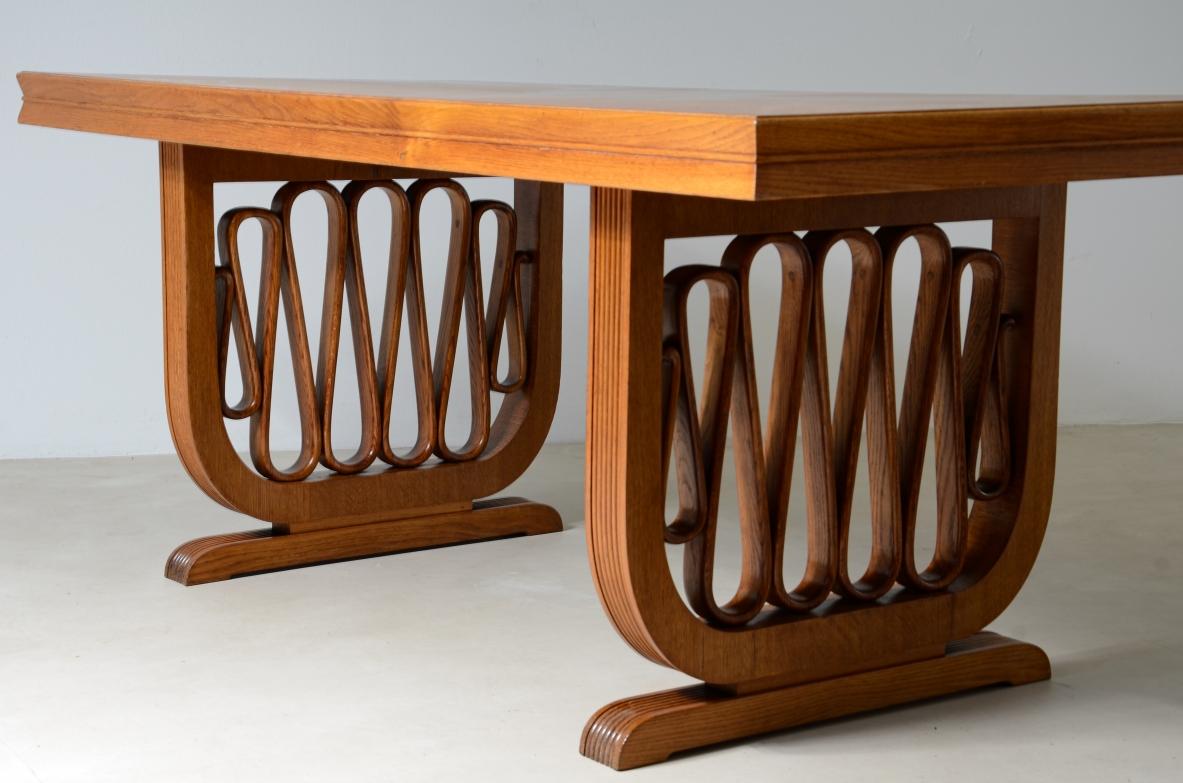 Extraordinary oak table with shaped uprights and ribbon motif in the style of the period, top with shaped thickness.

Italian manifacture, 1940s.