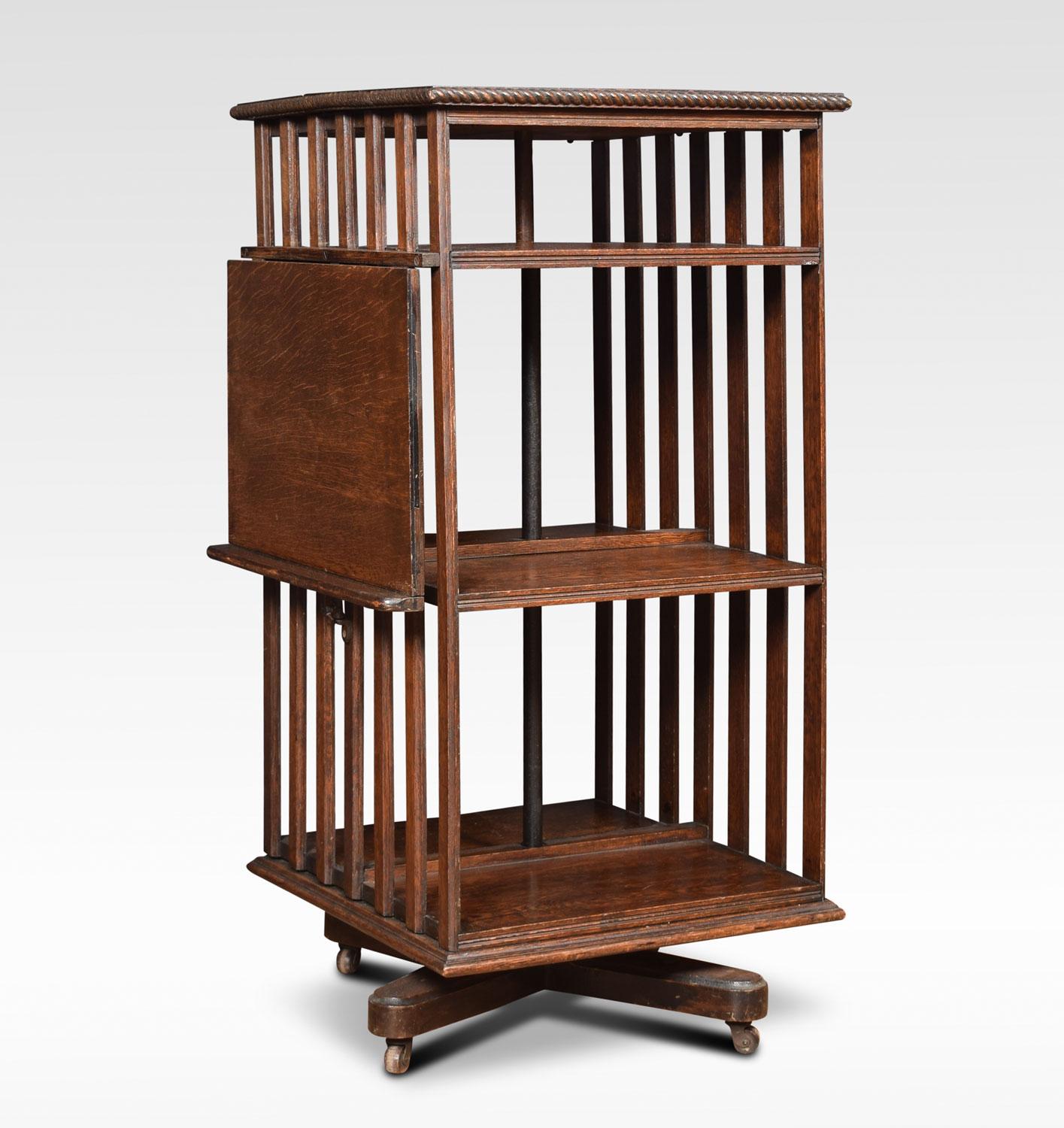 Oak three-tier revolving bookcase, the square moulded top above an arrangement of shelves, having unusual lift up reading rest to the side. All raised up on cruciform base, terminating in brass caps and ceramic castors.
Dimensions:
Height 41.5