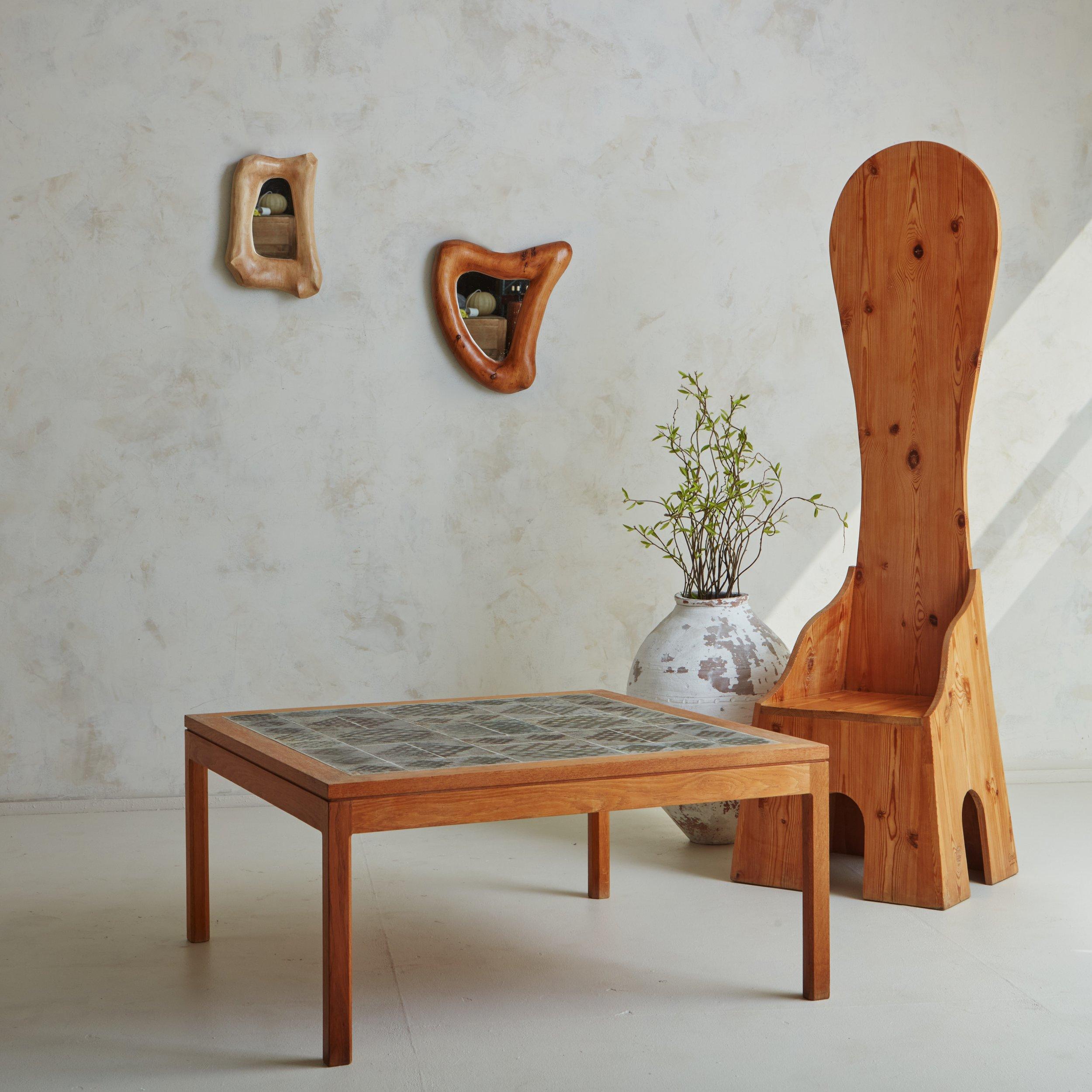 A 1970s coffee table by Danish ceramicist Tue Poulsen (b.1939). This table features a square oak wood frame with beautiful graining and block legs. It has a tile table top made from gorgeous hand painted unglazed stoneware ceramic tiles. Signed