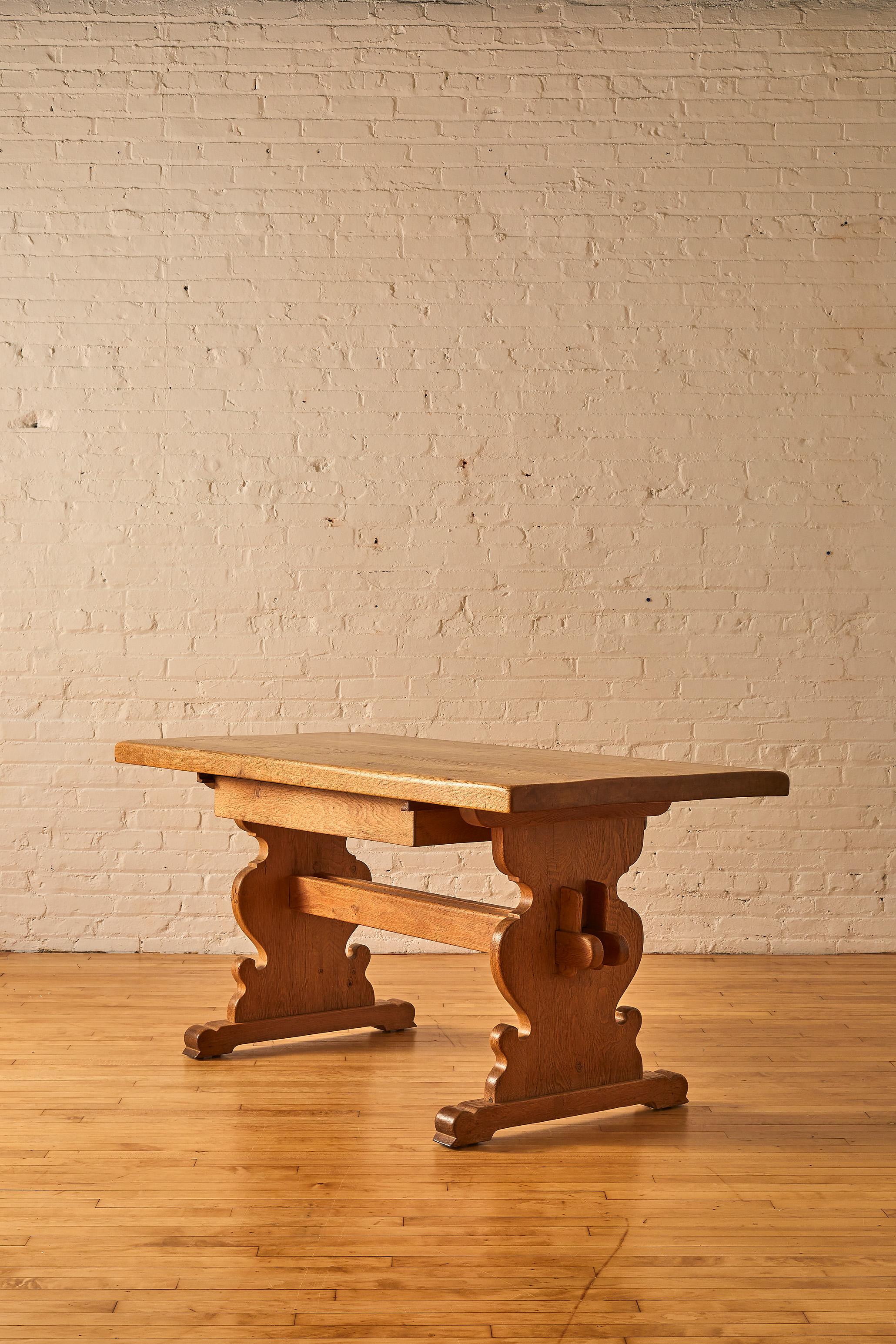 Heavy oak dining table with Trestle Base featuring a drawer with dual side access. 

