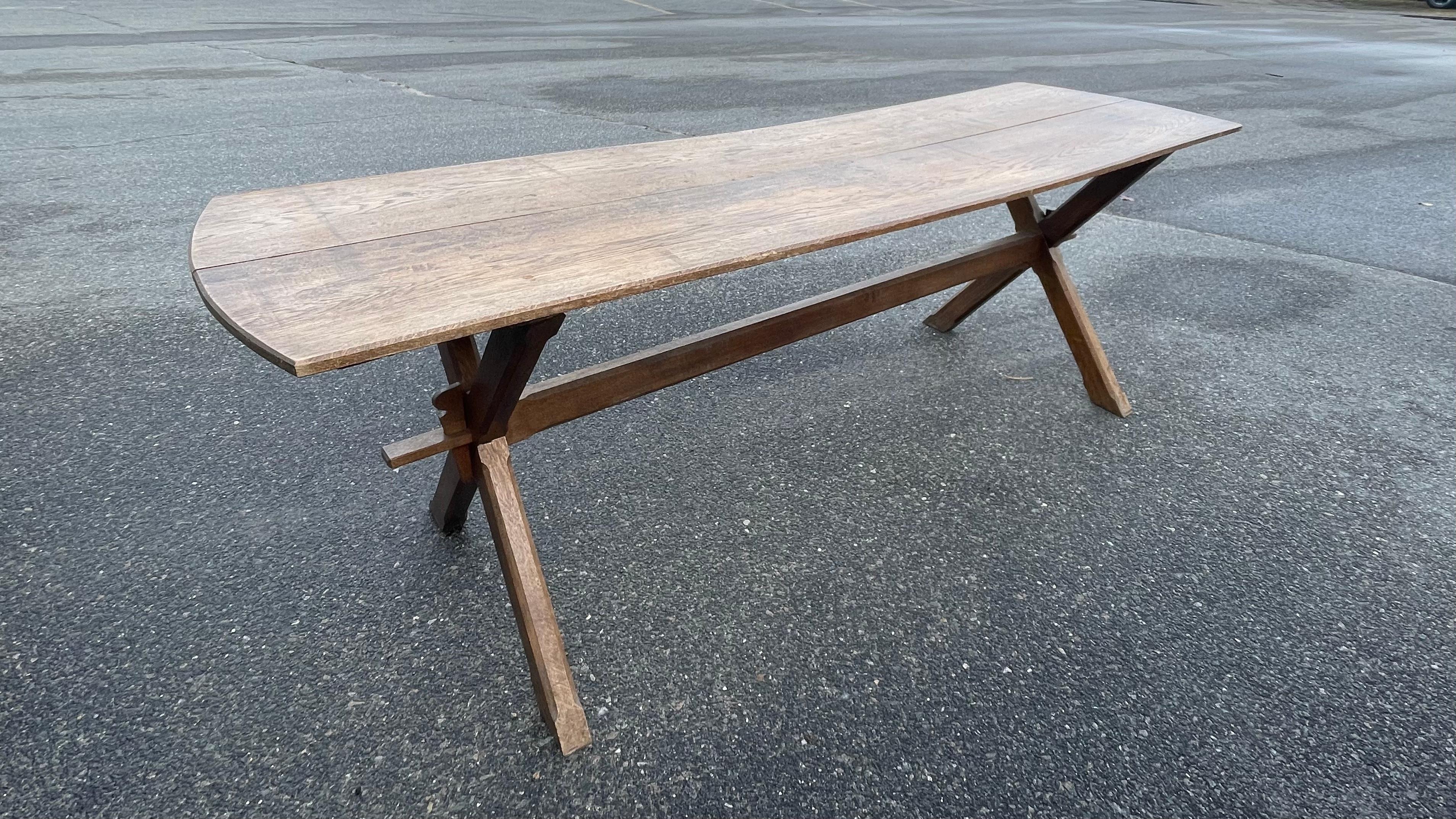 Lovely oak trestle table with antique two board top (one board with small old patch) and slightly curved ends.  X legs connected with single stretcher and all-over mellow patina.  The shallow depth of this piece makes it great for use as a console