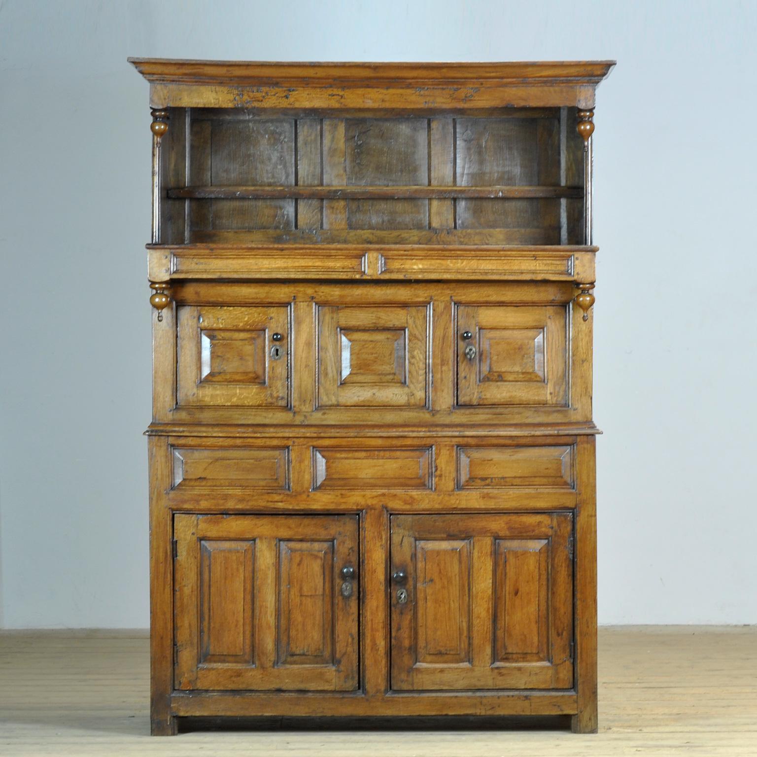 Un raffinato armadio tridarn in quercia dell'inizio del XVIII secolo (circa 1710), realizzato in Wales in tre sezioni. Il mobile ha una cornice modellata sopra uno spazio aperto sopra tre ante del mobile. La parte superiore era utilizzata per