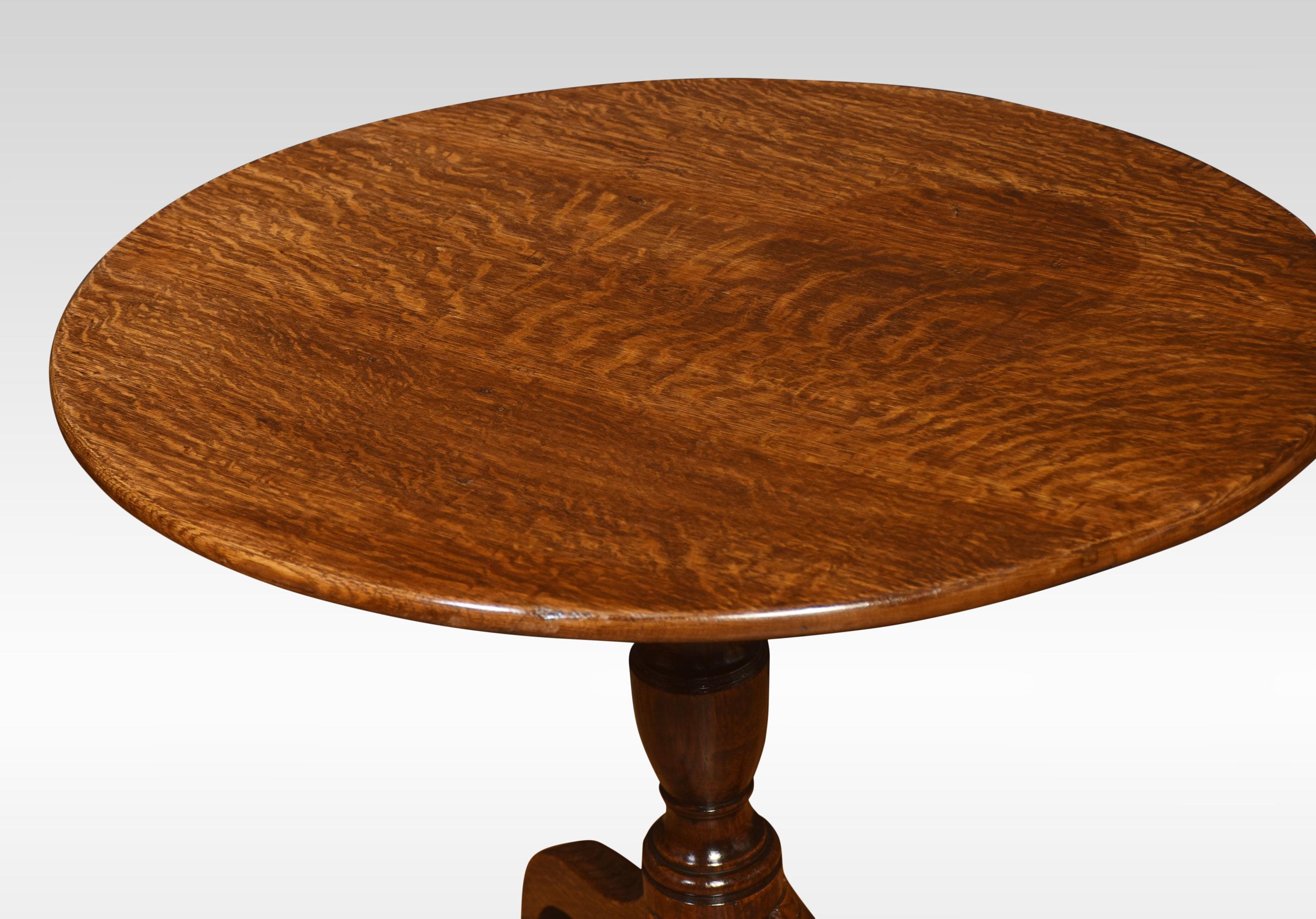 Oak tripod table, the circular top above ring-turned pedestal. All raised up on three down swept supports terminating in spade feet.
Dimensions
Height 27 Inches
Width 30.5 Inches
Depth 30.5 Inches.