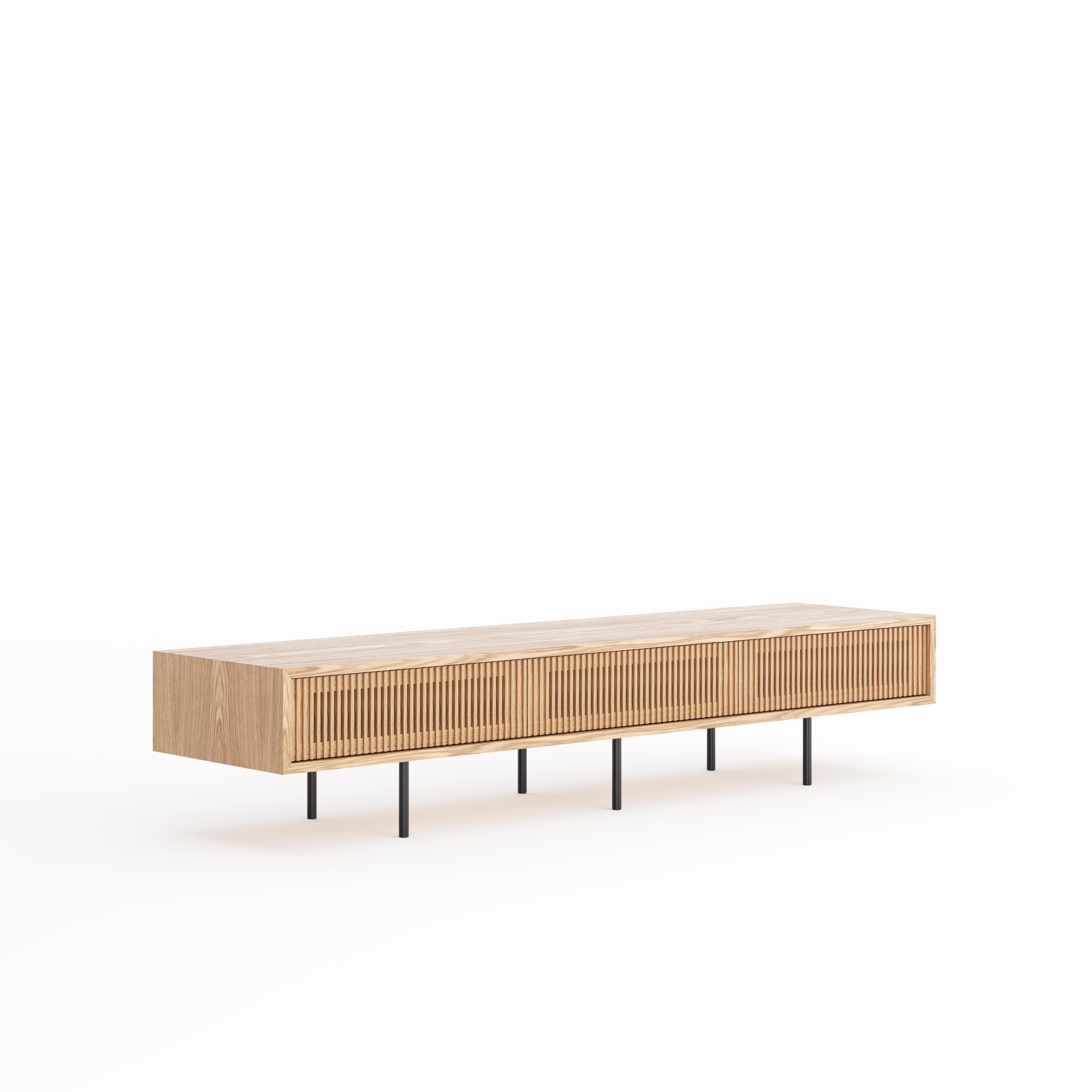 Oak lowboard with three slatted doors and simple aluminum black legs in mid century modern style.
Perfect as a TV stand or media console for music enthusiasts. Lot of storage space to accommodate media equipment and accessories.
Lowboard made of