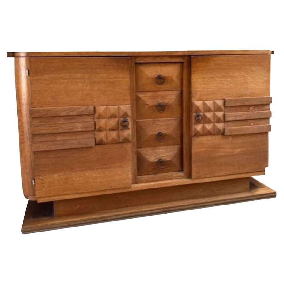 Mid century French oak credenza with two doors and four drawers.
In the style of Charles Dudouyt.
Decorative raised footing.
Pyramid shaped drawers between the two front doors remain visible when doors are open.
Smaller pyramid shaped design and