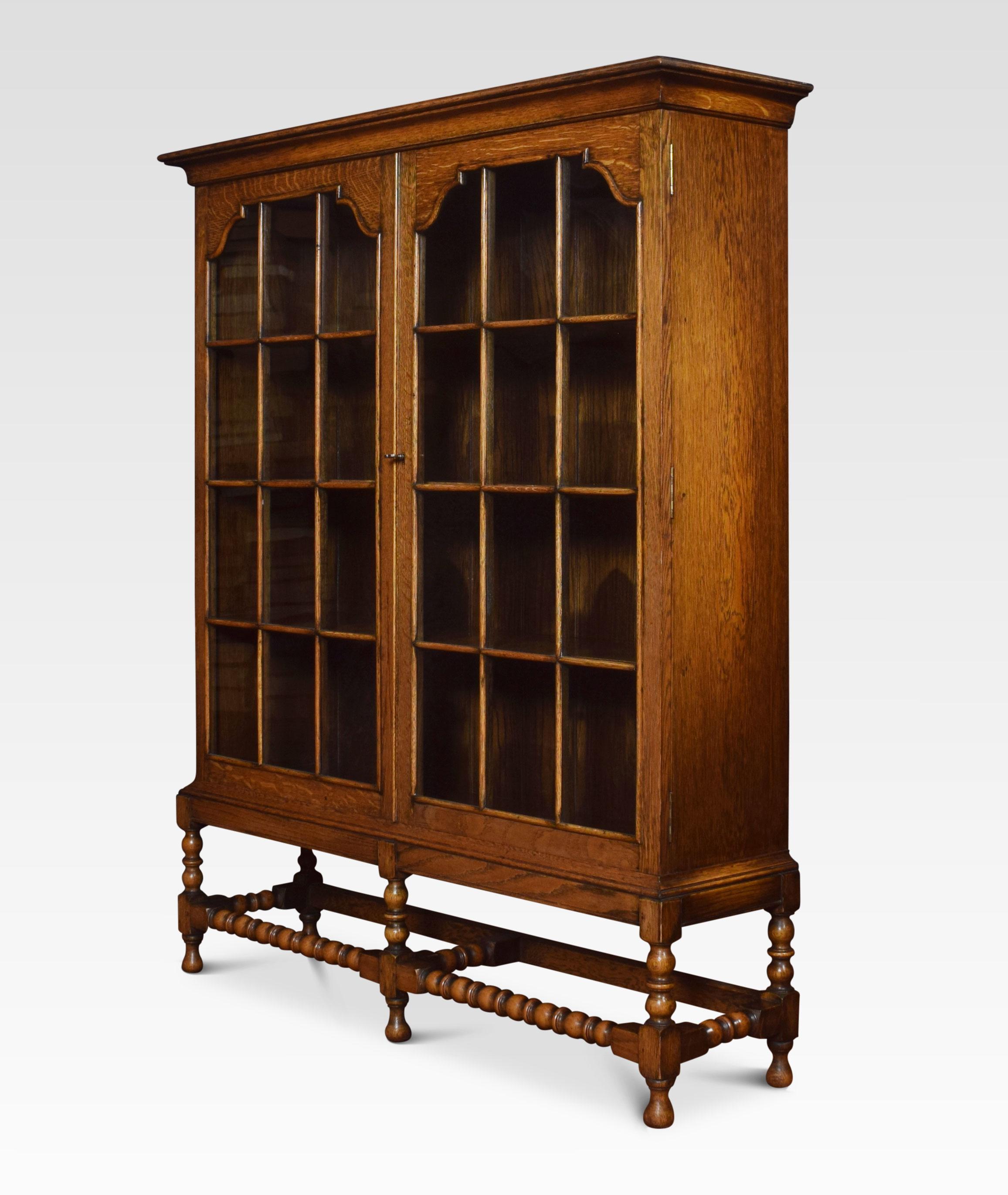 Oak bookcase the large rectangular top above two glazed beaded doors opening to reveal a shelved interior. All raised up on five barley twist supports united by stretchers.
Dimensions:
Height 54 inches
Width 44.5 inches
Depth 12 inches.