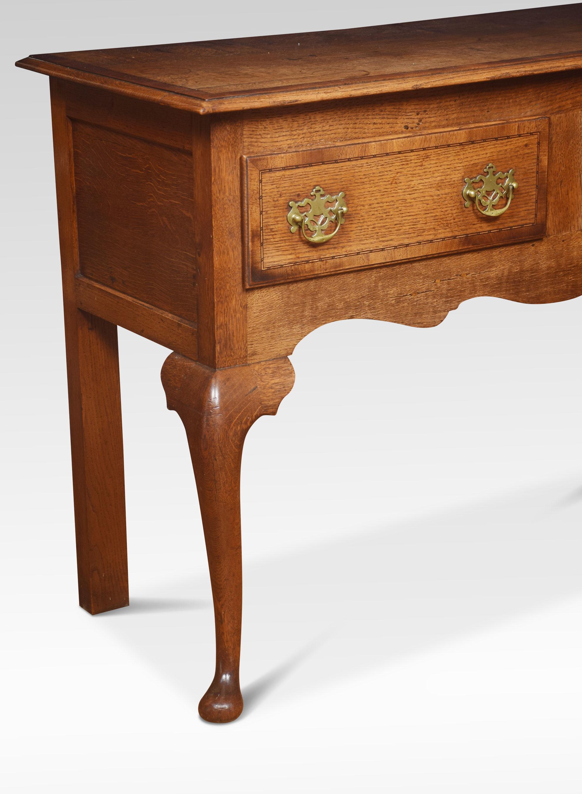 Oak dresser the large rectangular top with crossbanded border and molded edge. To the frieze fitted with two drawers having brass swan neck handles. All raised up on slender cabriole supports terminating in pad feet.
Dimensions
Height 32.5