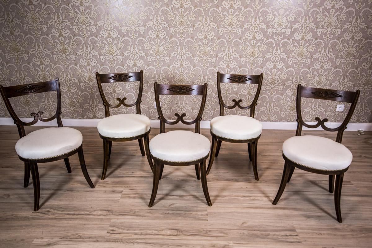We present you this set of five chairs made of oakwood, with softly upholstered seats.
The chairs are supported on legs in the Greek type. The backrests are two-tier.
The upper crosspiece has a carved decoration in a frame made of stretched