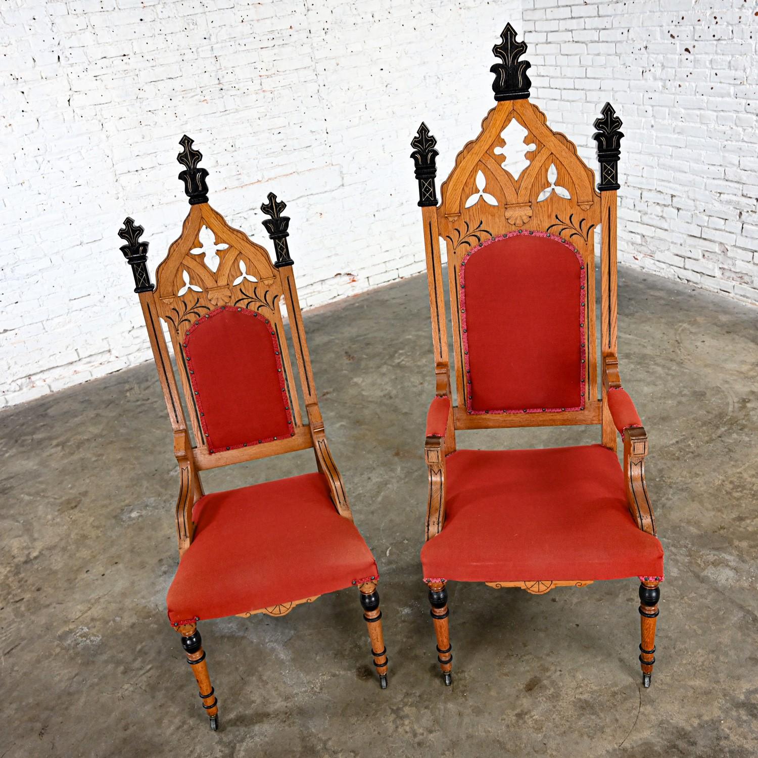 Incredible Late19th Century to Early 20th Century Victorian or Gothic Revival Ecclesiastical His & Hers Throne Chairs comprised of oak frames with black and gold details, red hopsacking fabric on backs & seats with gimp and nail head trim & turned