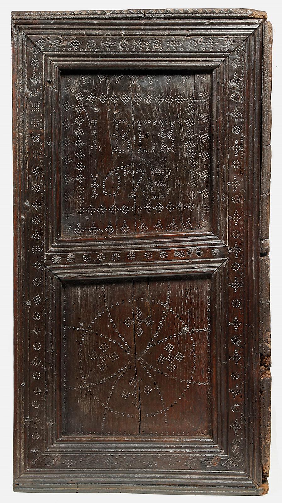 Charles II oak wall cupboard, English, Yorkshire, circa 1673.

The single panel door with applied moldings simulating paneled construction, decorated all-over with punch and stencil patterns. With twin end molded panels similarly decorated, the