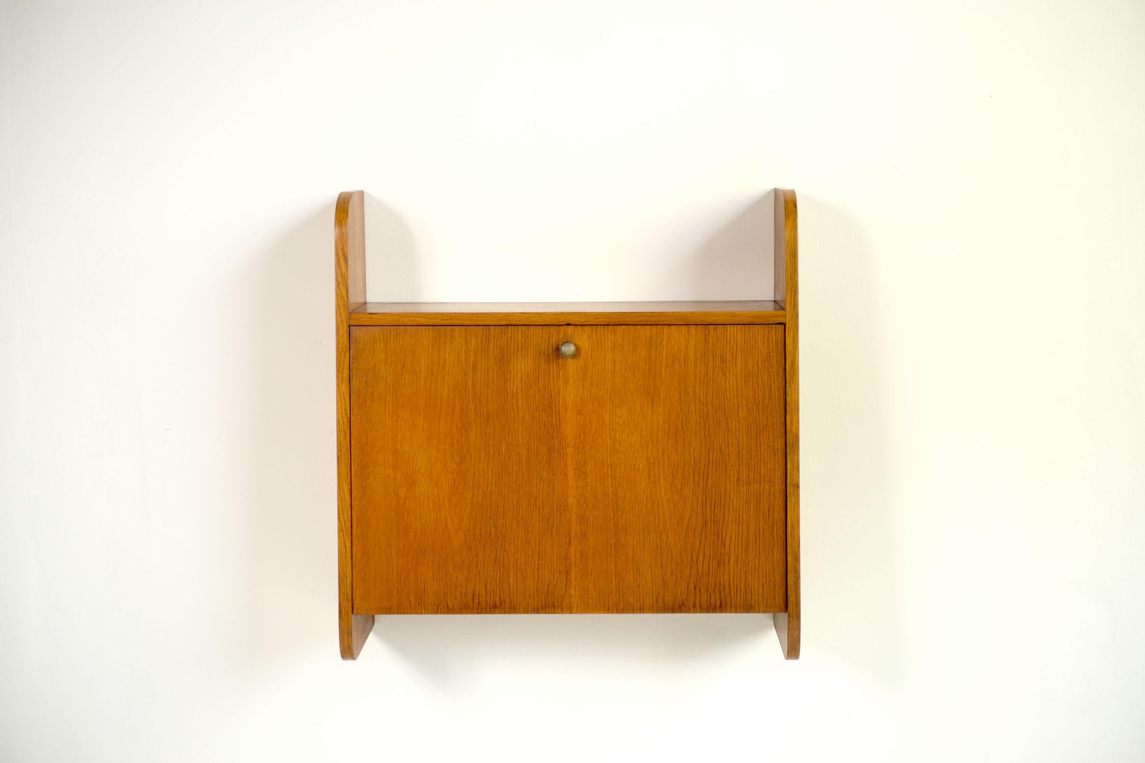 Wall secretary in slatted plywood, blond oak veneer, French reconstruction 1950. The large flap opens to form a writing desk (depth 64 cm). Inside, a molded shelf and a small drawer. With its dimensions and layout, this pretty wall-mounted desk is