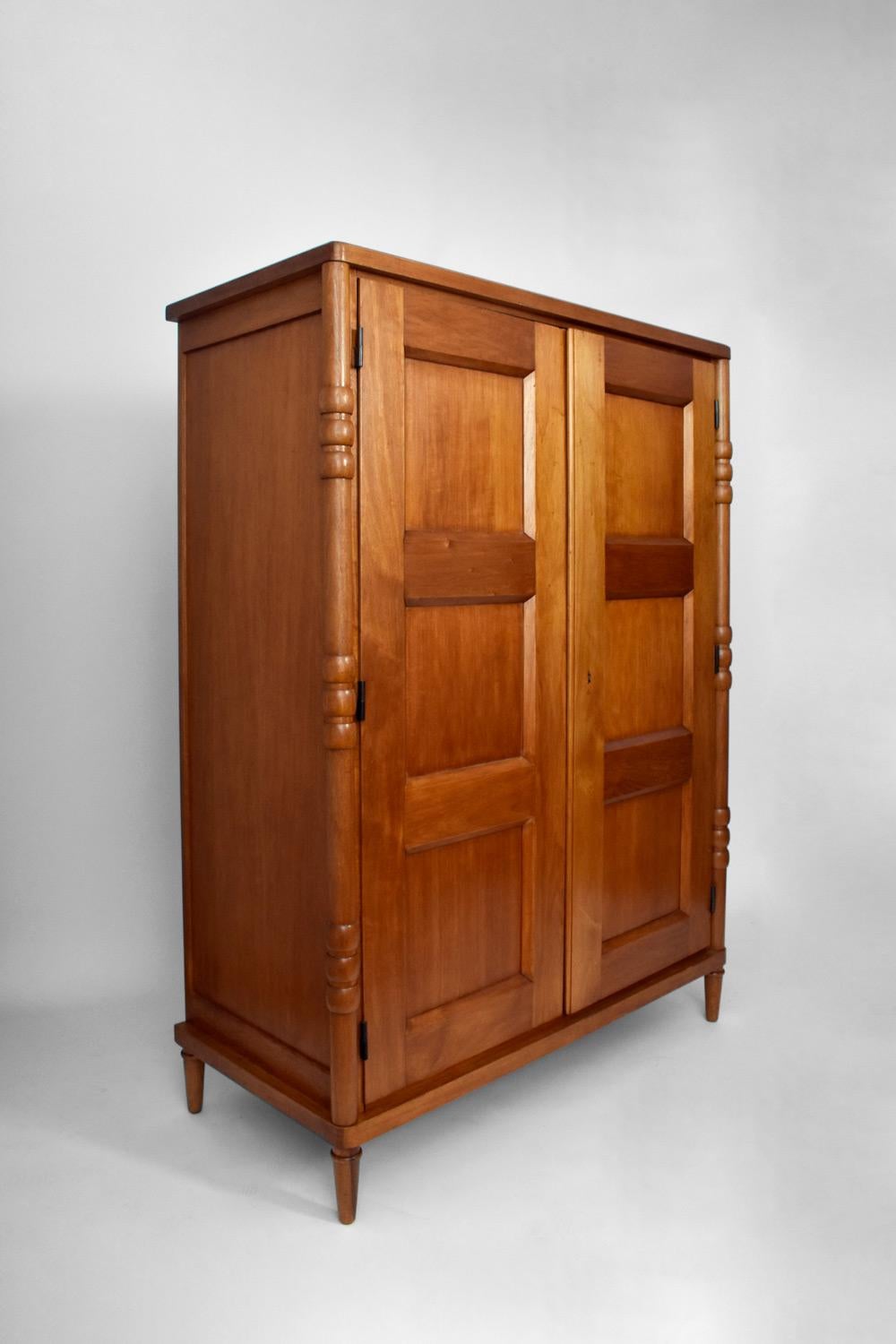 Oak cabinet resting on four tapered legs surmounted by turned wooden uprights and opening by two doors in front. France, 1950s.