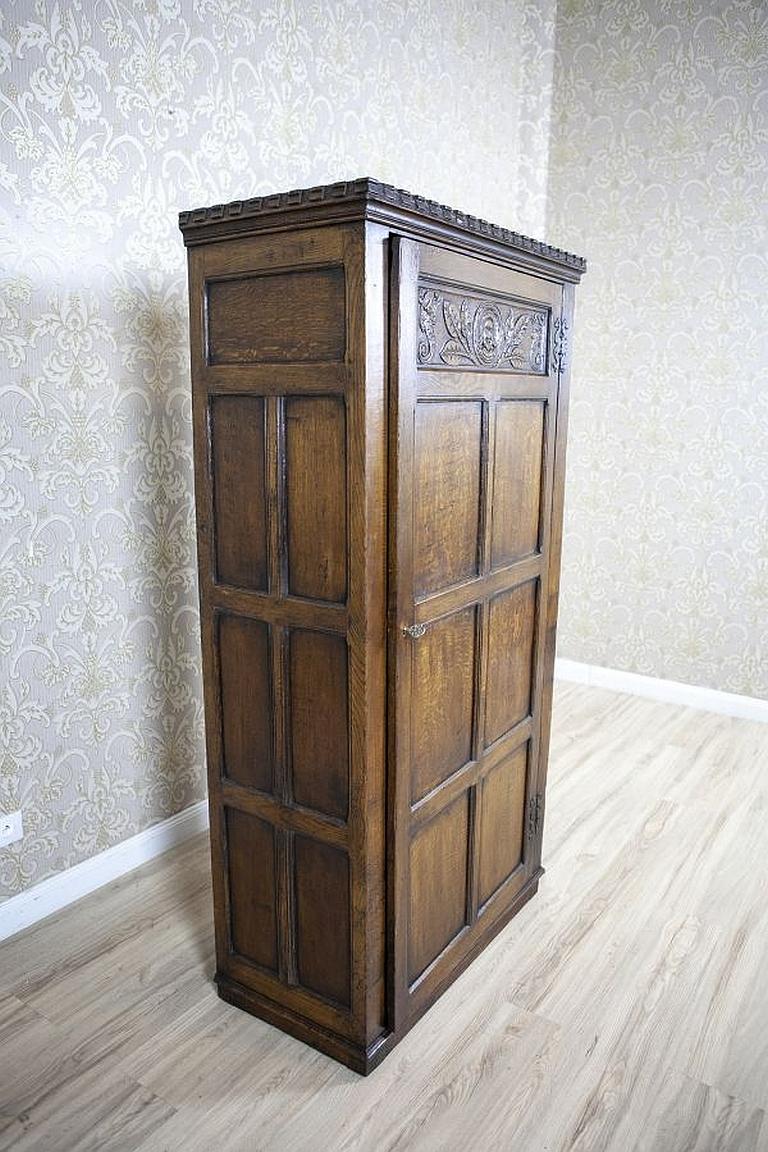Richly Carved Oak Wardrobe From the Turn of the 19th and 20th Centuries

This simple in its form one-door piece of furniture is made of oak. The socle and crowning cornices are slightly advanced over the surface. The upper section of the door panels