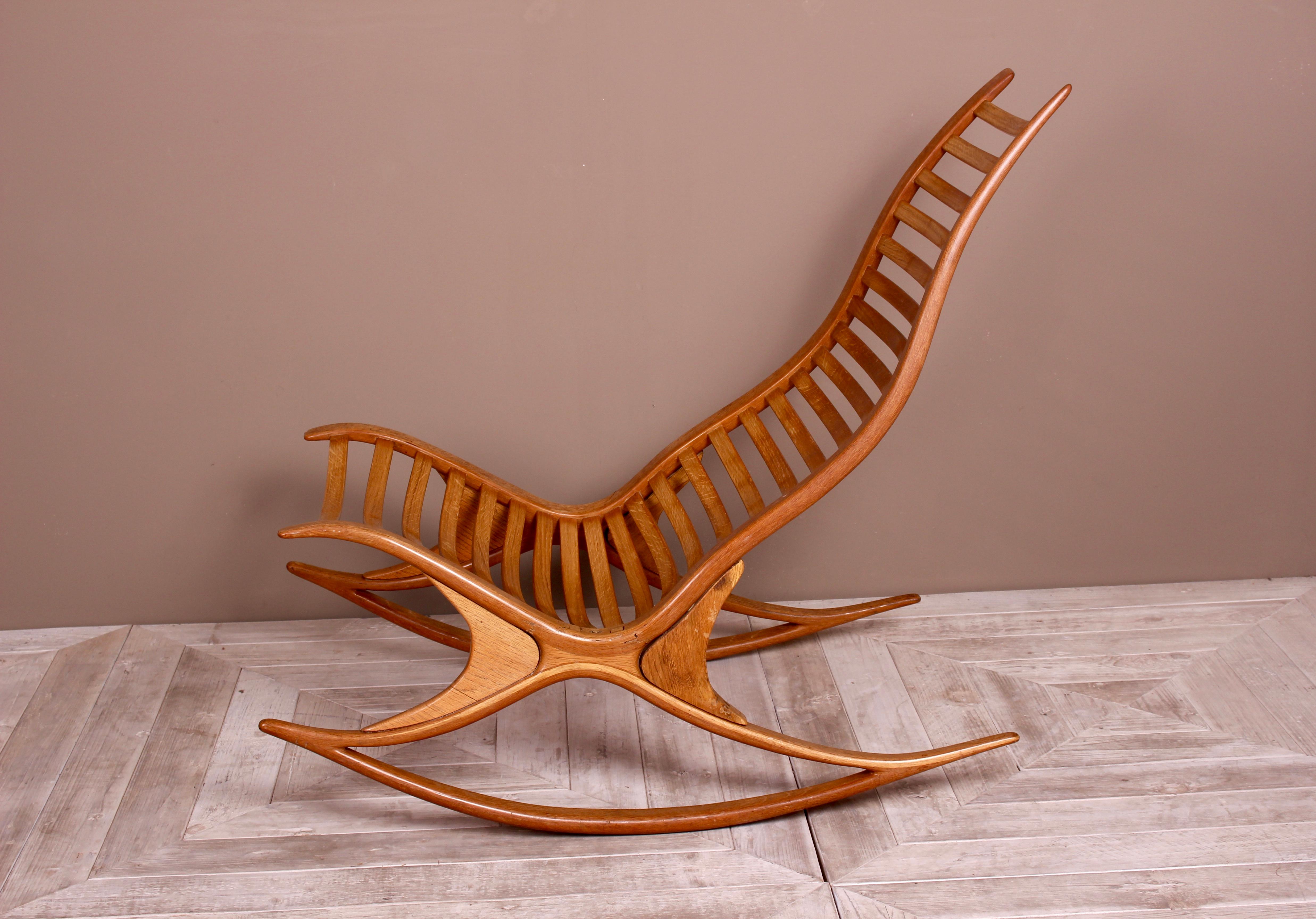 A stunning oak wishbone rocking chair by Robin Williams, circa 1970s. A beautiful wishbone frame supports the ladder-back seat. Comes with an optional leather seat pad which is easy to attach or remove via popper buttons. The piece has been