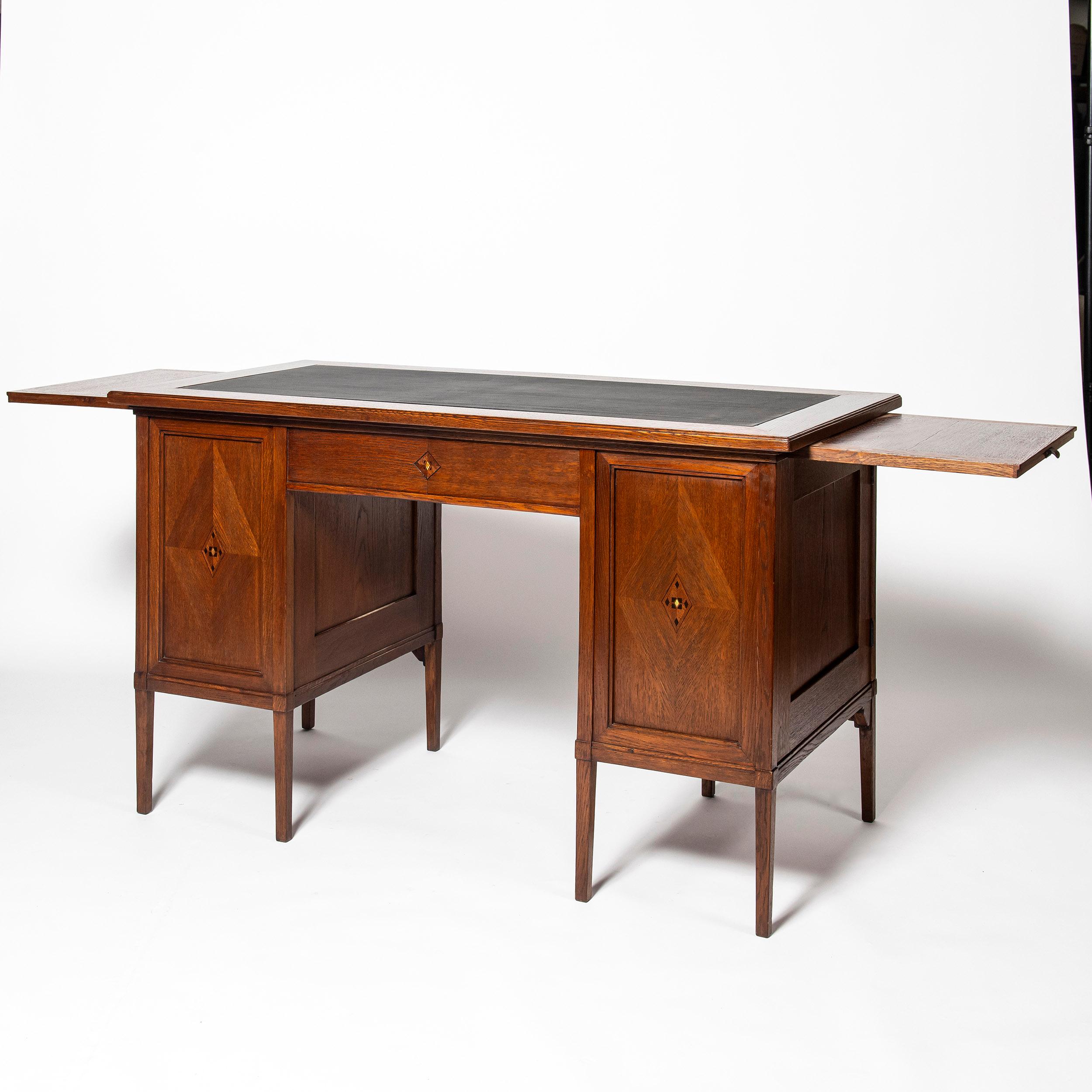 Oak wood, iron and leather desk. Scotland, early 20th century.
With wood marquetry.
Arts & Crafts period.