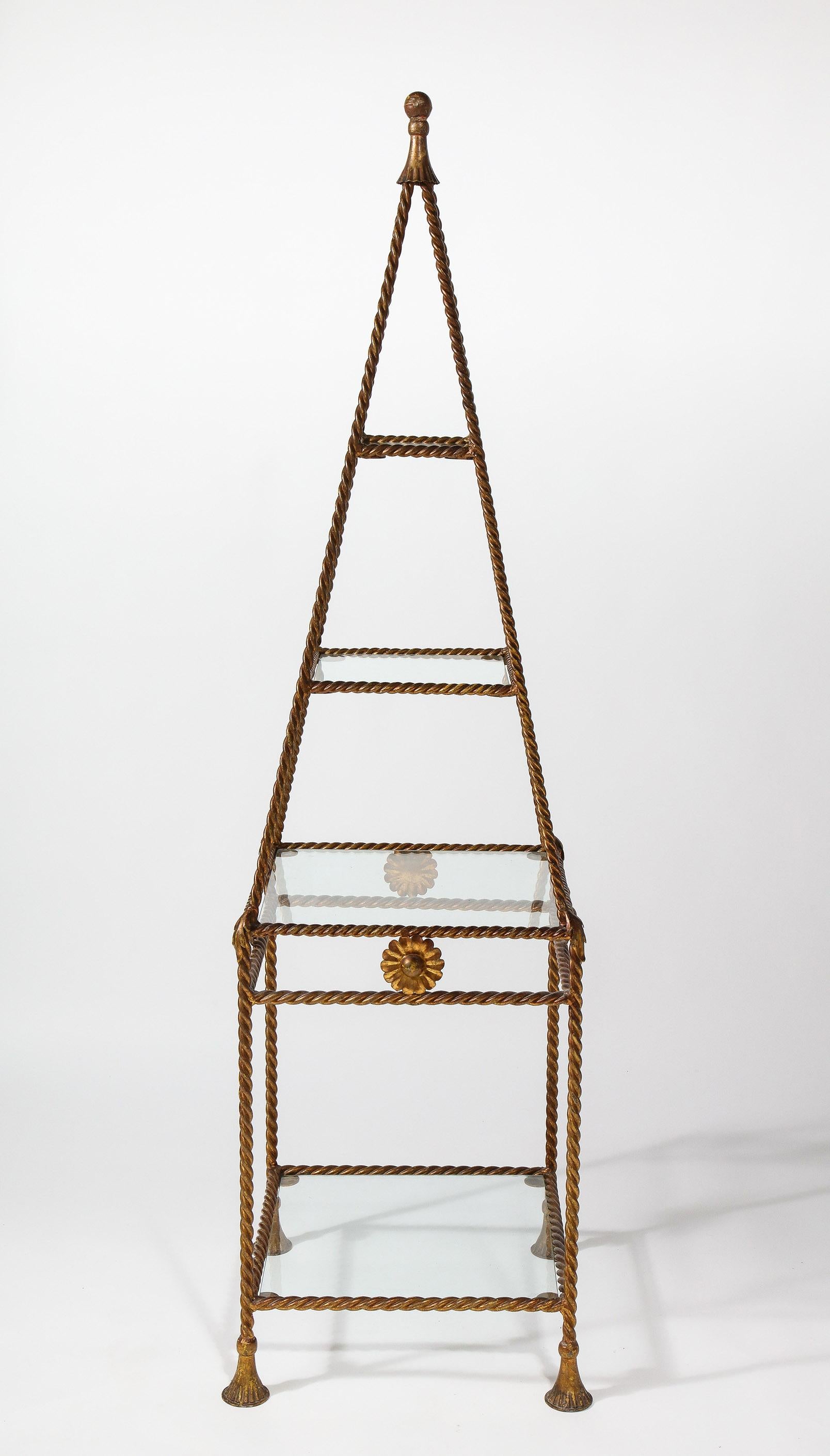 The elegant étagère having four gradated square glass shelves set into a gilt metal rope and tassel frame.